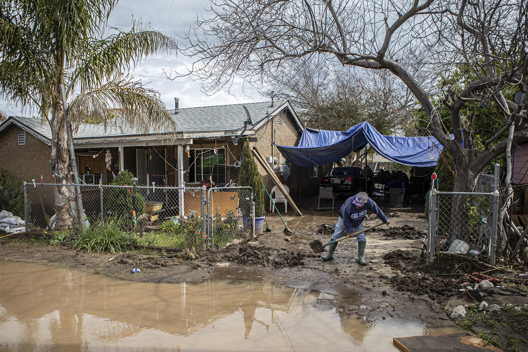A Cutler resident shovel mud off his driveway in Cutler on March 12, 2023. The area was recently flooded after the levee in the area was breached during a series of storms that hit the Central Valley. Photo by Larry Valenzuela, CalMatters/CatchLight Local
