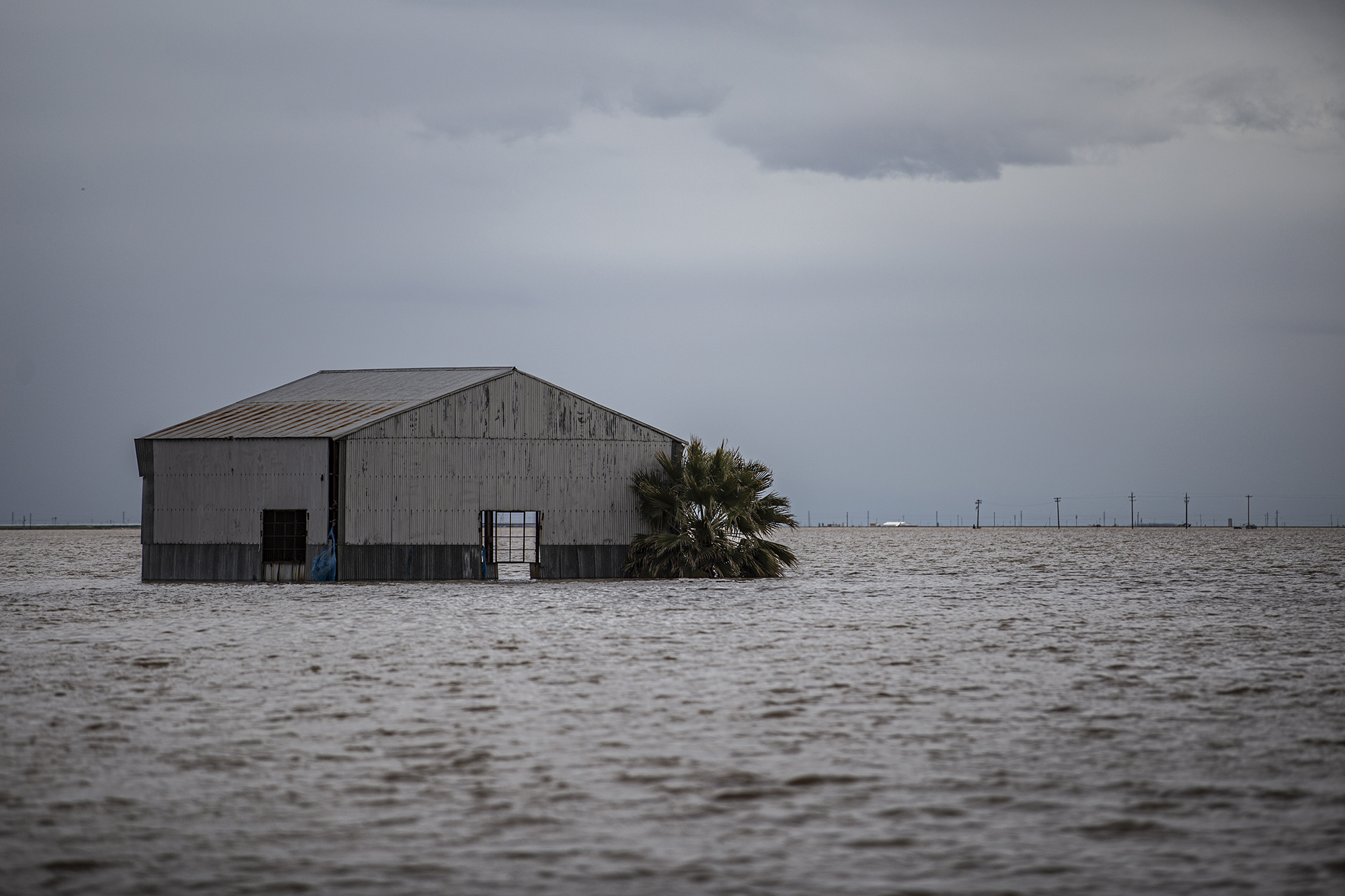 A trucking company warehouse in farmland flooded around Dairy Avenue near Hansen Ranches south of Corcoran March 22, 2023. 