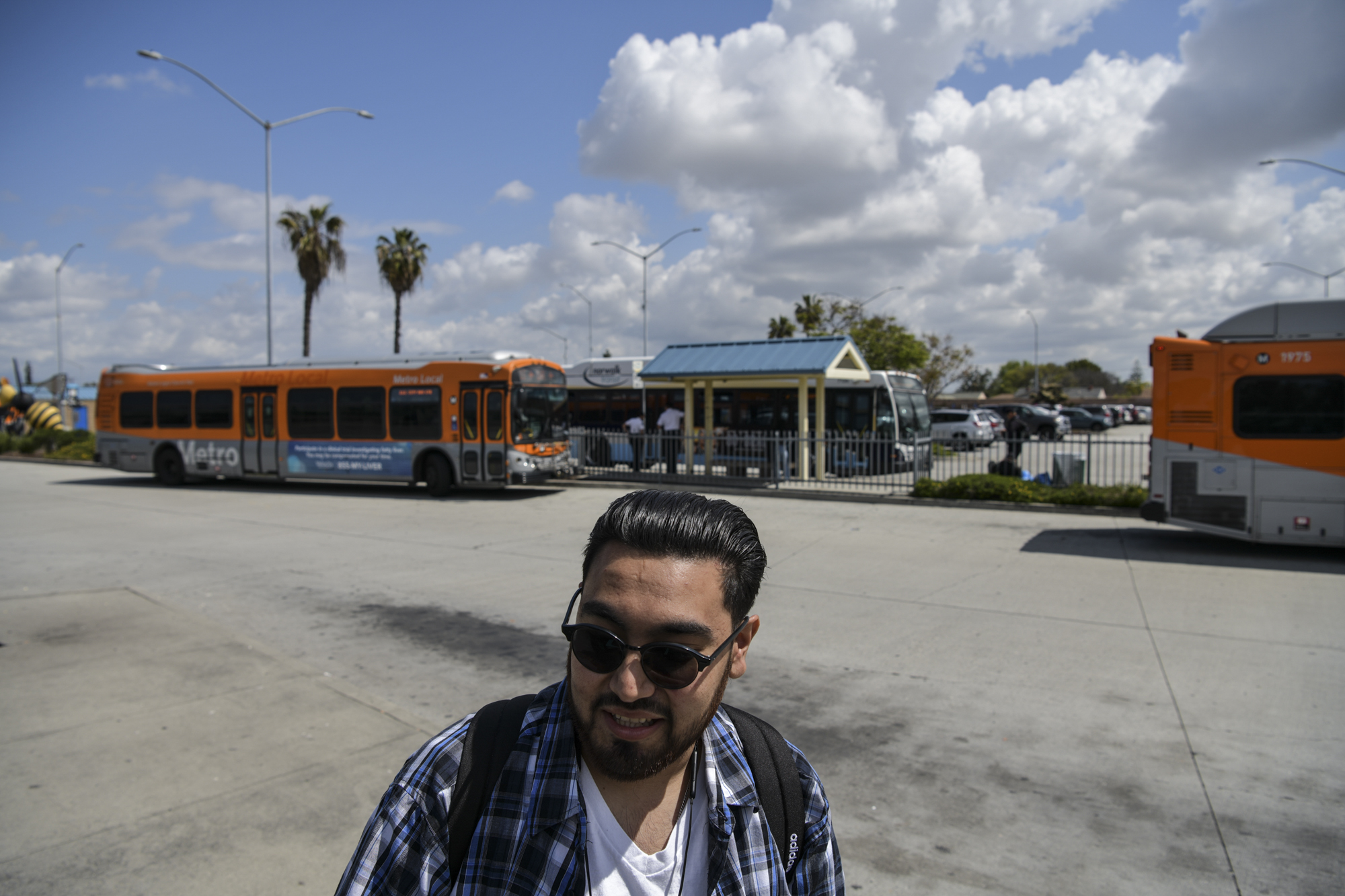 Henry Sanchez, 22, who lives in Bell Gardens, waits for the Metro bus to arrive at the Norwalk Green Line Station in Norwalk on April 3, 2023. Photo by Pablo Unzueta for CalMatters