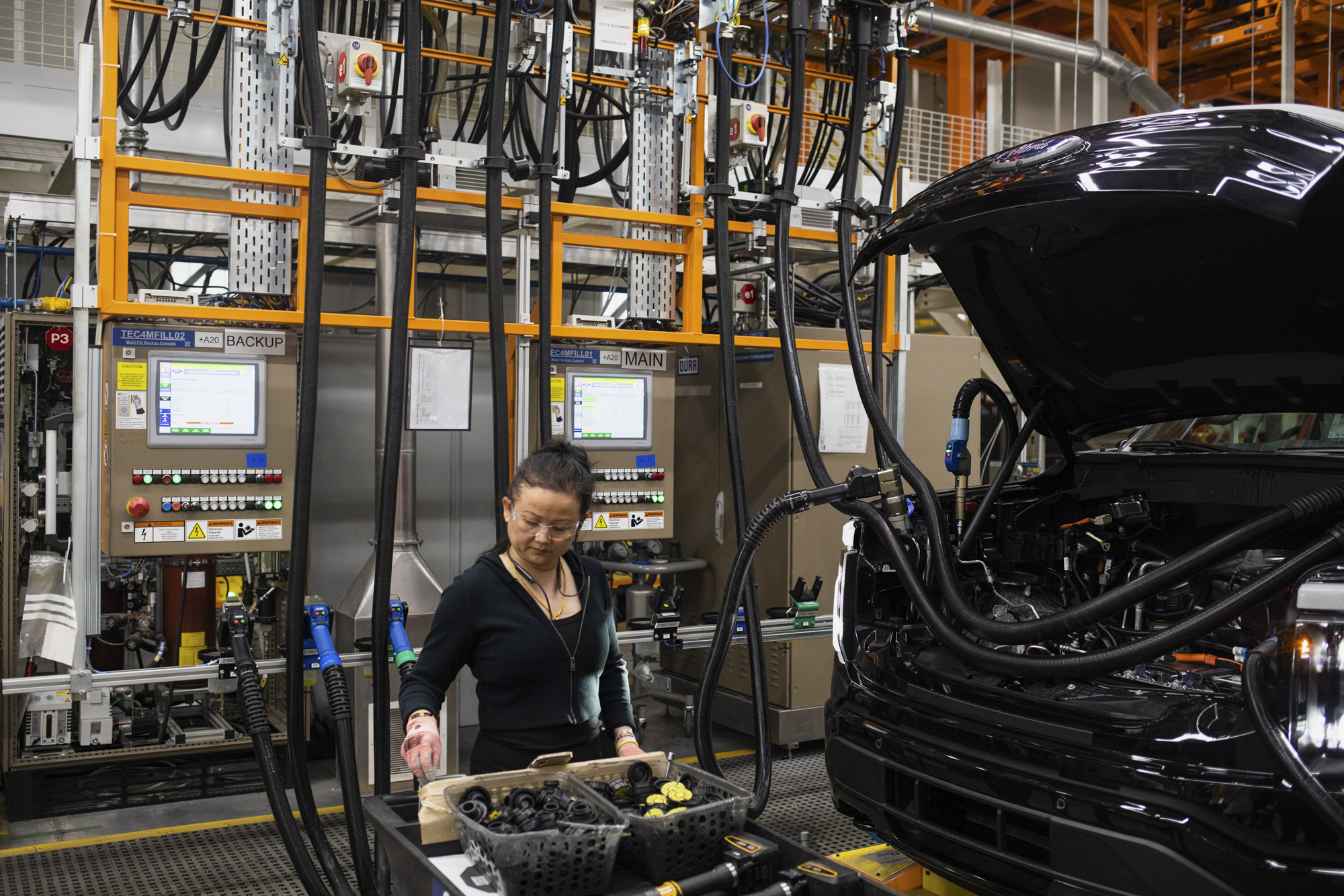 A worker tends to an electric Ford F-150 vehicle on the assembly line at the Ford River Rouge complex in Dearborn, Michigan on April 4, 2023. Photo by Emily Elconin for CalMatters