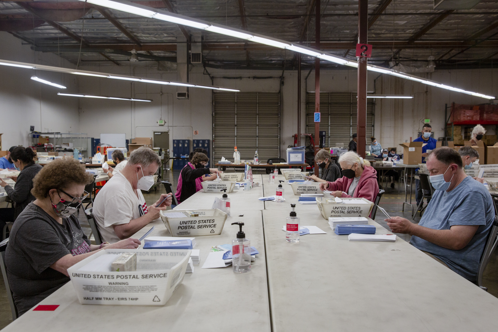 VistAbility workers pack envelopes with BART Clipper card information to be mailed and assemble mirrors for bicycle helmets into plastic packaging on Thursday, April 27, 2023. Photo by Shelby Knowles for CalMatters