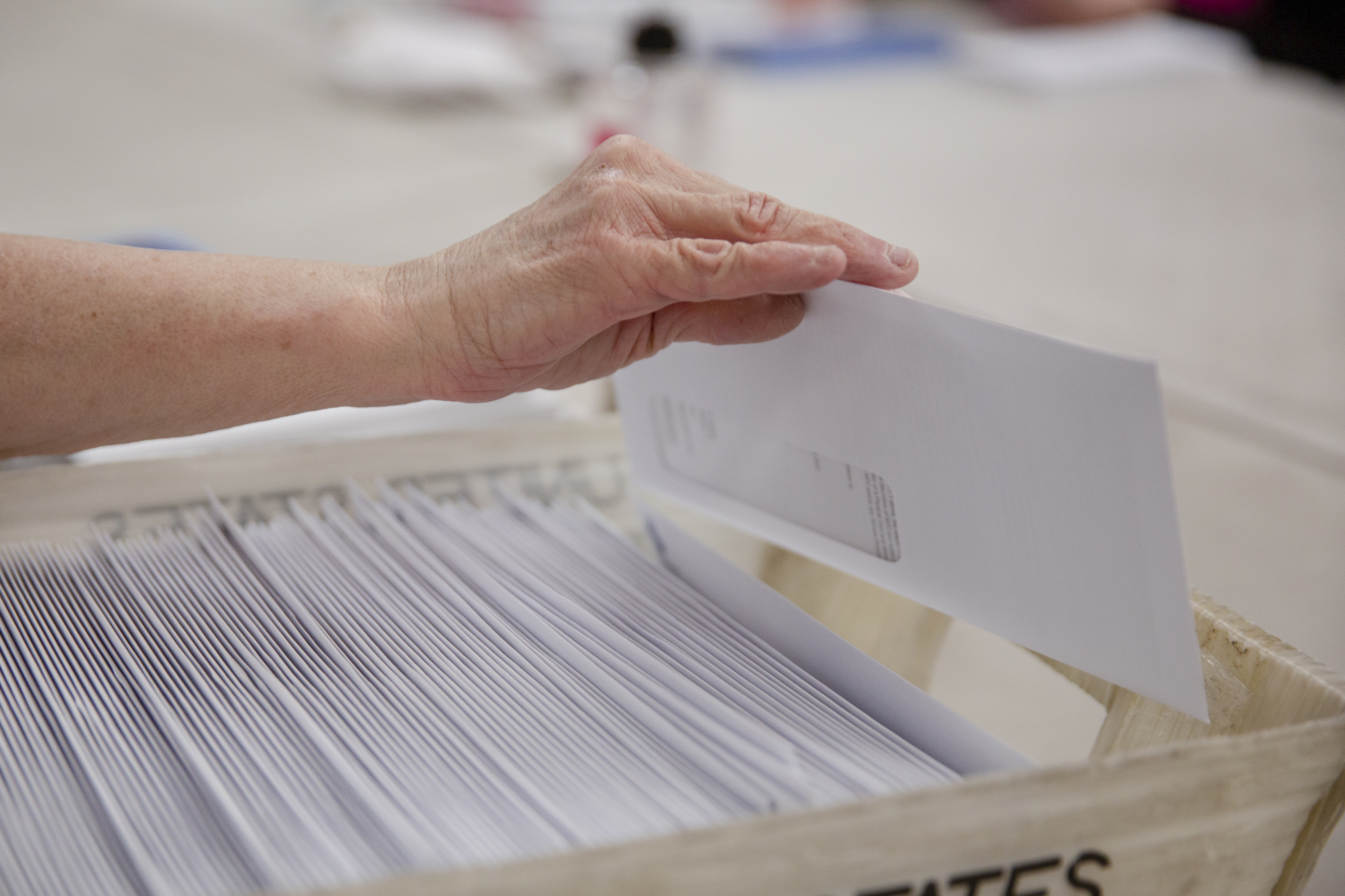 VistAbility workers pack envelopes with BART Clipper card information to be mailed and assemble mirrors for bicycle helmets into plastic packaging on April 27, 2023.