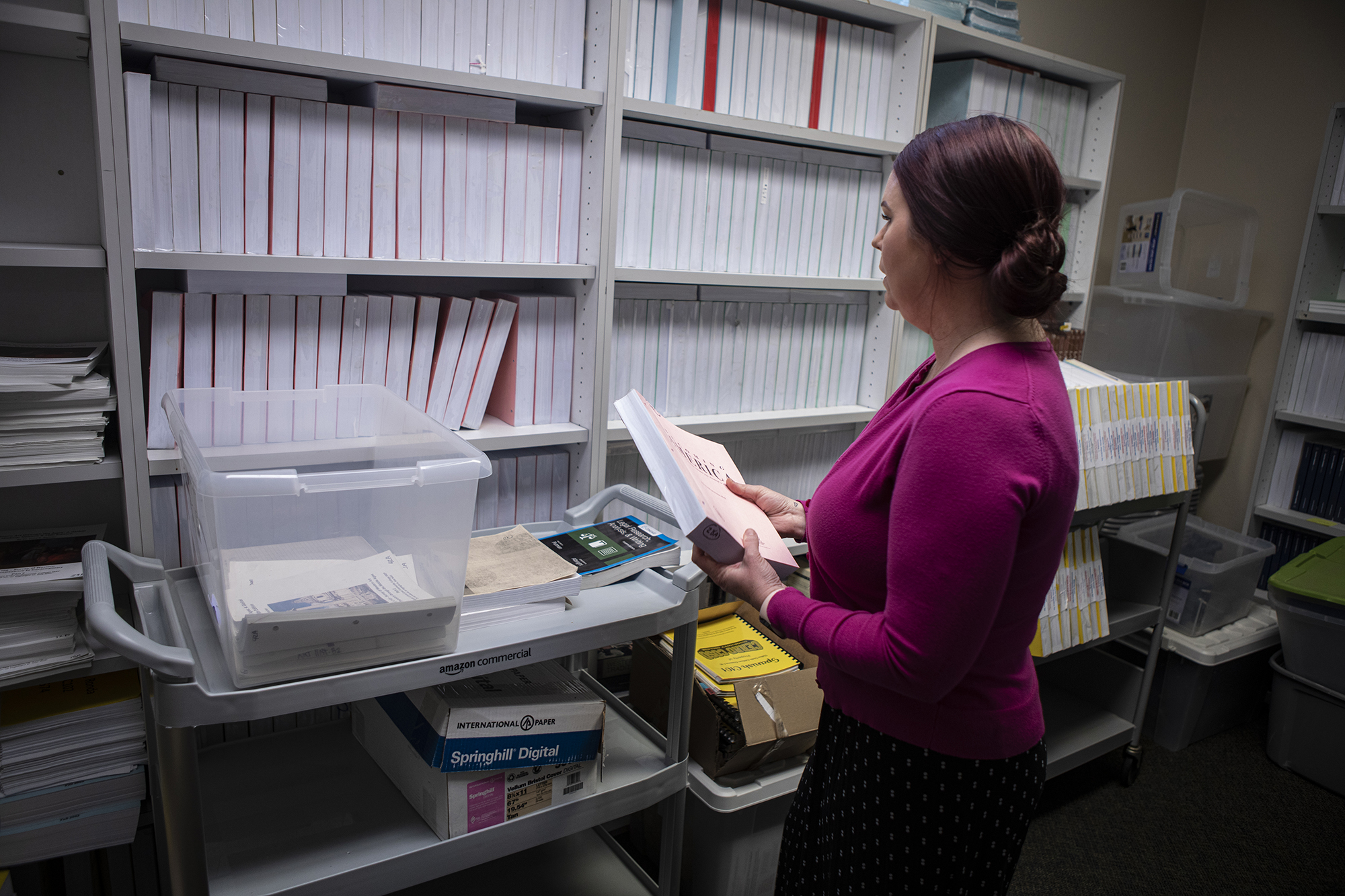 Anna Carlson, the program director for the incarcerated education program, looks over books meant for inmates at Cerro Coso office in Tehachapi on May 10, 2023.