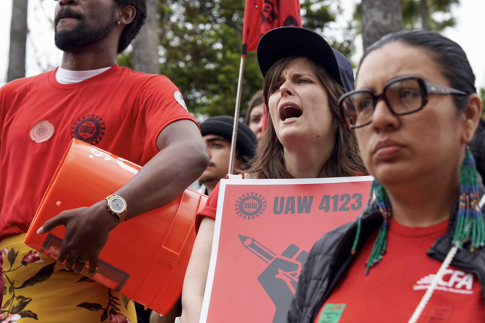 Emma Joslyn, center, a member of UAW 4123, and Nora Cisneros, right, with CFA, during the rally. Members of Teamsters, CSUEU, UAW 4123 and CFA Faculty gathered to ask for fair wages outside the CSU Chancellor's office in Long Beach on May 23, 2023. 
