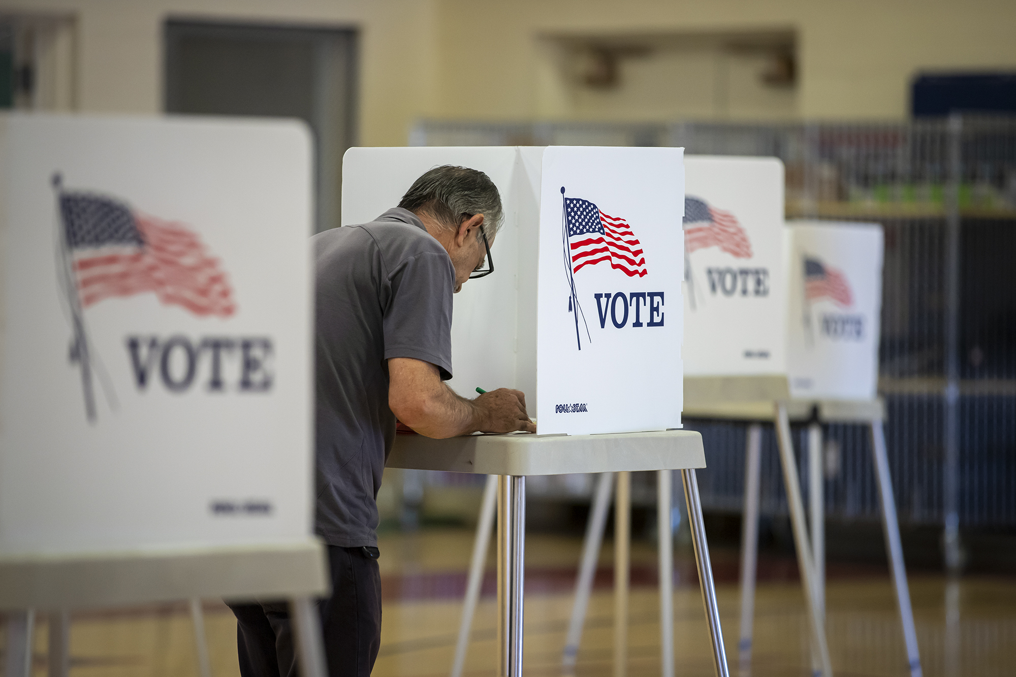 A voter fills out their ballot at a voting site at the Hamilton School gymnasium in central Fresno on June 7, 2022. Photo by Larry Valenzuela, CalMatters