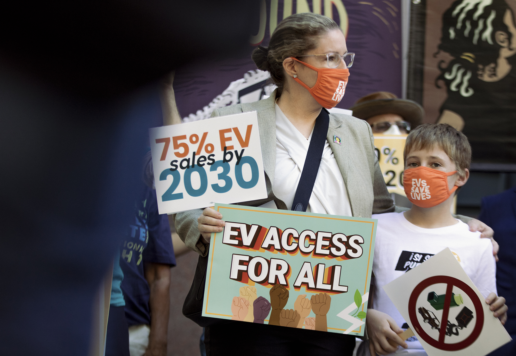 Community organizer Lori B. Pesante, of the Dolores Huerta Foundation and her son Dorius, at a rally calling for 100% electric vehicle consumer use, at the California Environmental Protection Agency building in Sacramento on June 9, 2022. Photo by Rahul Lal, CalMatters
