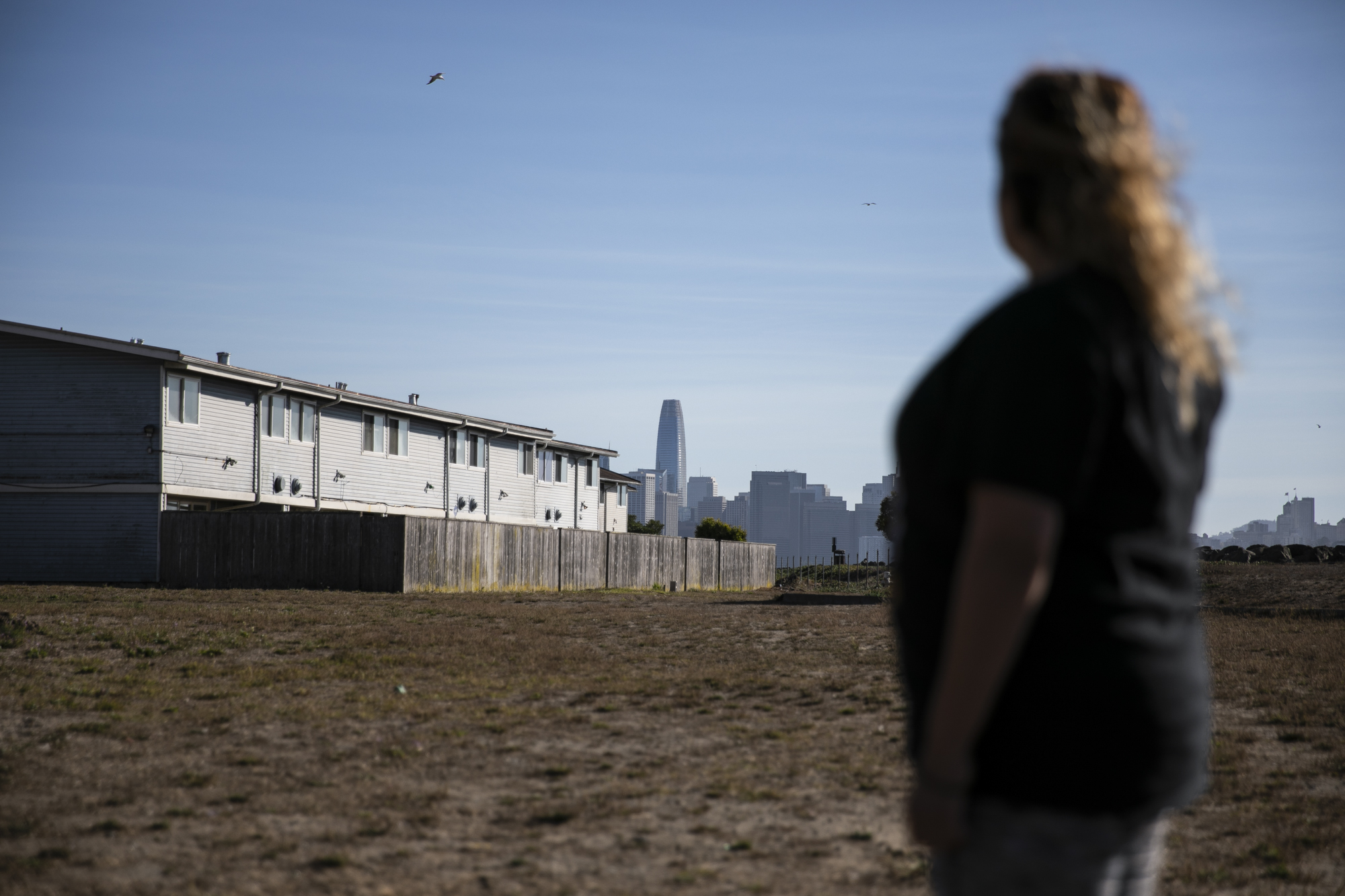 Mayra Perez can see the financial district in San Francisco from outside her home on Treasure Island. Photo by Martin do Nascimento, CalMatters