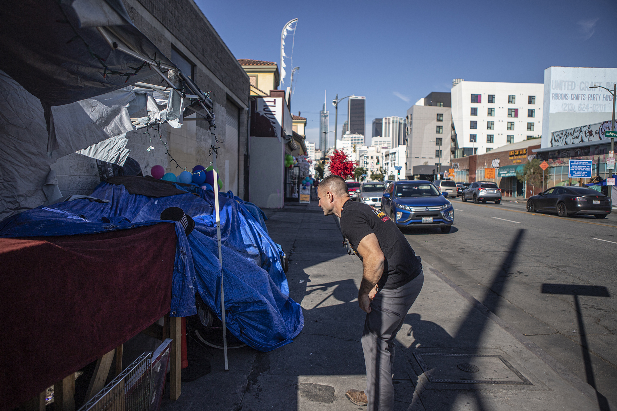 Physician's assistant Brett Feldman asks a man in his encampment if he has seen a patient along Skid Row on Nov. 18, 2022.
