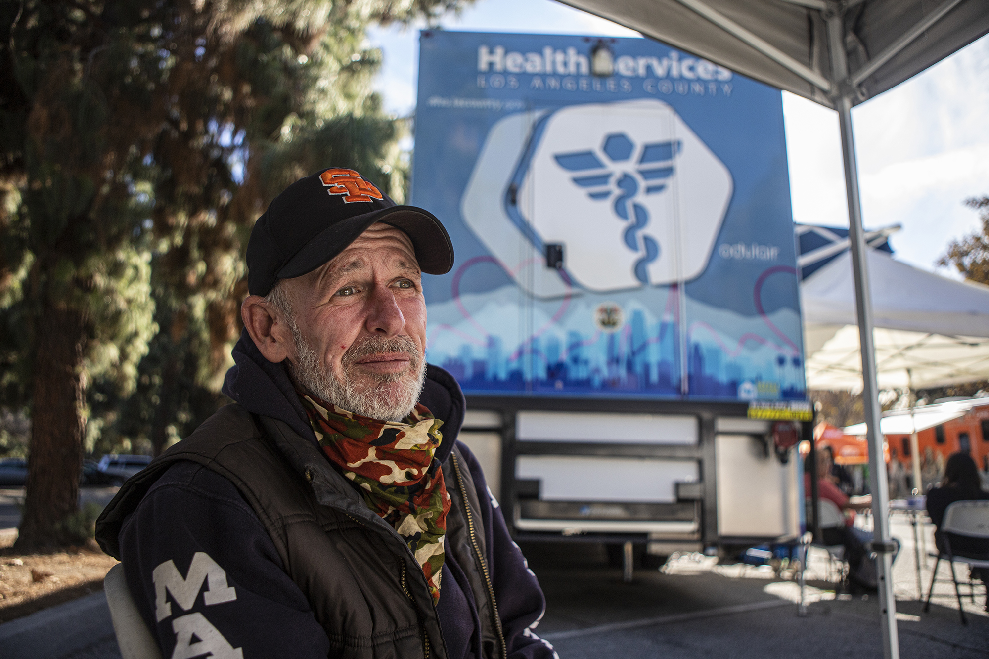 Unhoused patient Danny Doran sits in the waiting area for the mobile clinic parked in Whittier Narrows Park on Nov. 17, 2022. Doran is being checked up after being assaulted near his encampment just a few days before.