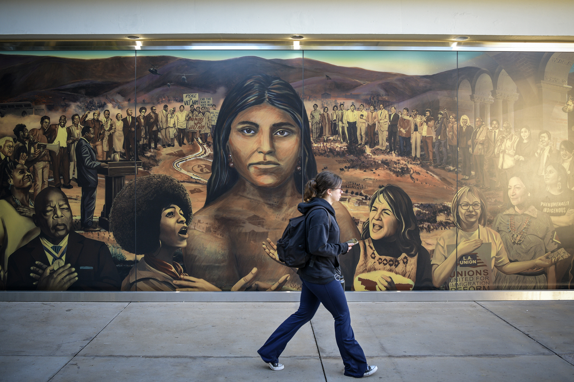 “La Memoria de la Tierra,” a mural created by Judith Baca, resides on the north side of Ackerman Union at UCLA in Los Angeles on Nov. 9, 2022. The mural is approximately 80 feet and made up of three 26-foot-long glass panels. Pablo Unzueta for CalMatters