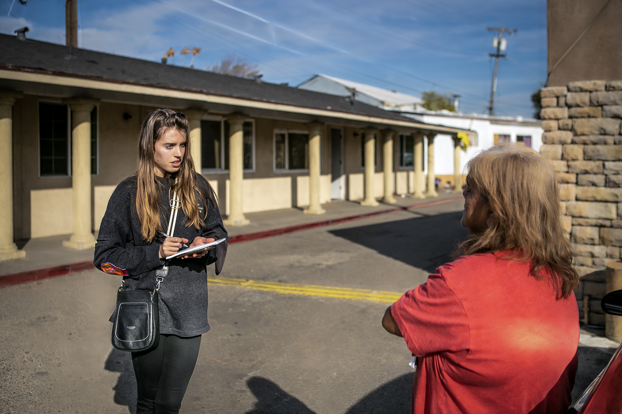 CalMatters housing reporter Manuela Tobias (left) interviews Marina Salinas at her residency at the Stockton City Hotel in Stockton on Nov. 22, 2022. Photo by Rahul Lal, CalMatters