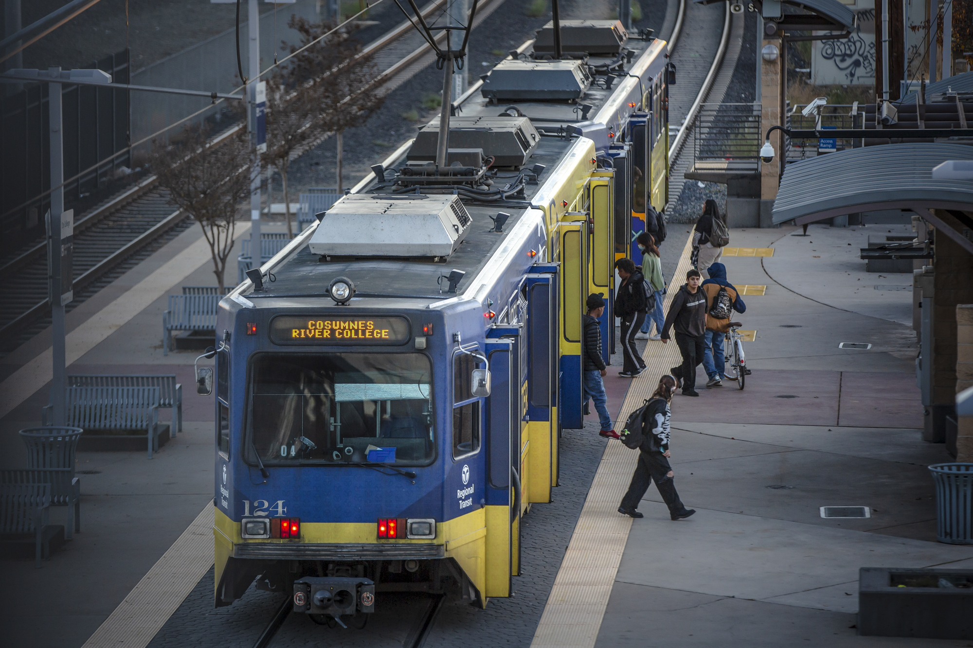 Passengers board a Sacramento Regional Transit light rail bus at Sacramento City College in Sacramento on Nov. 30, 2022. Photo by Rahul Lal, CalMatters