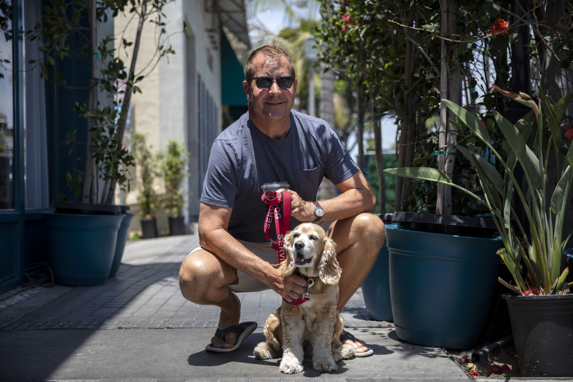 Manhattan Beach resident David Sulaski is pictured with his dog Stella in Manhattan Beach on Friday, May 27, 2022. Sulaski said he is in favor of cannabis shops opening in Manhattan Beach. He said it doesn't make sense to make people drive elsewhere when Manhattan Beach could benefit from having cannabis shops within the town. Photo by Alisha Jucevic for CalMatters