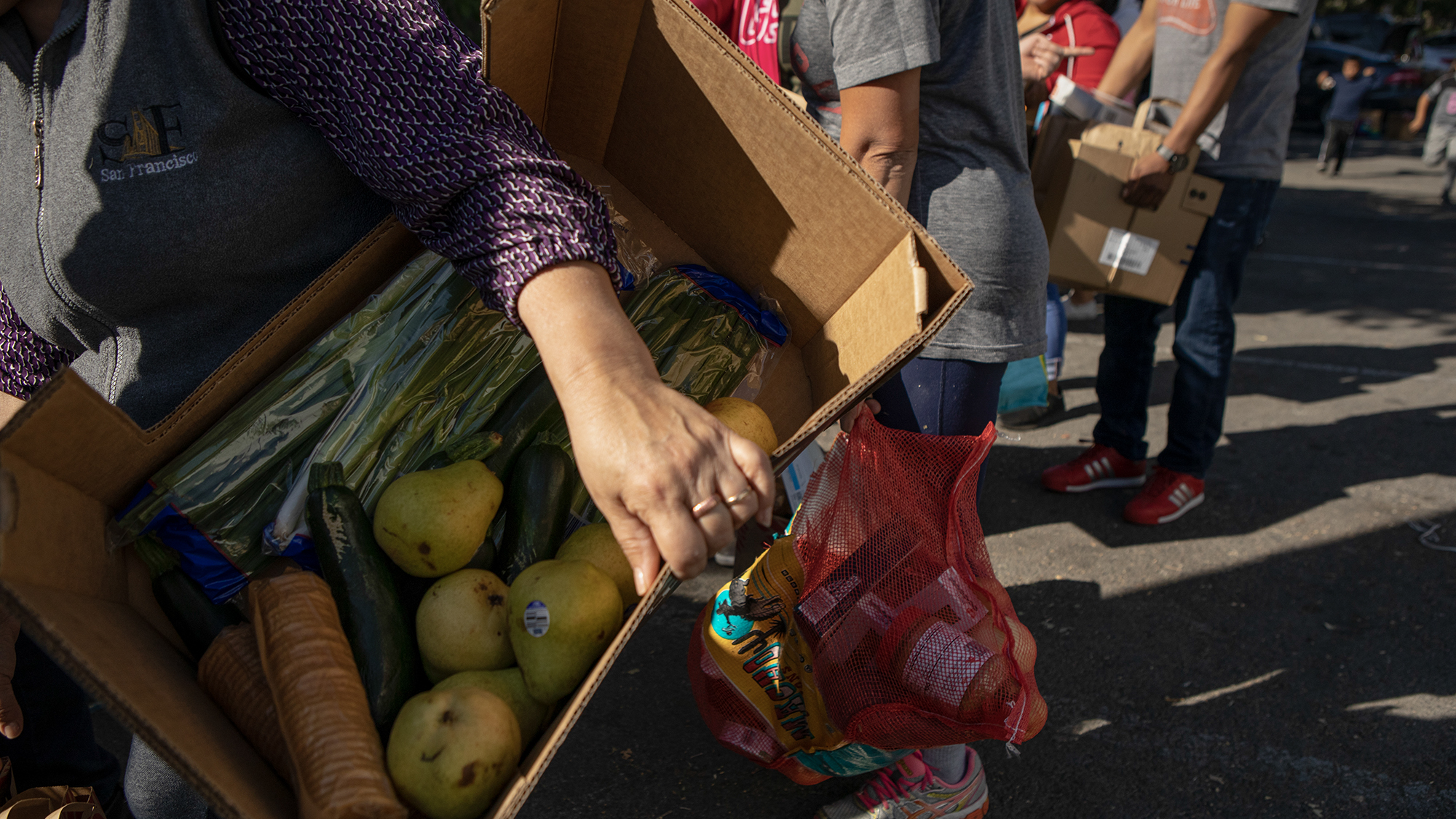 Families carry boxes full of fresh produce during a food bank event at El Verano elementary on Nov. 1, 2019. Photo by Anne Wernikoff, CalMatters