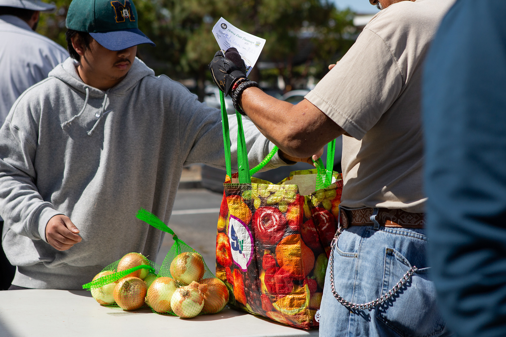 Volunteer Kim Palma passes out fresh produce at the Solano County Mobile Food Pharmacy in Fairfield on Aug. 1, 2023. Photo by Semantha Norris, CalMatters