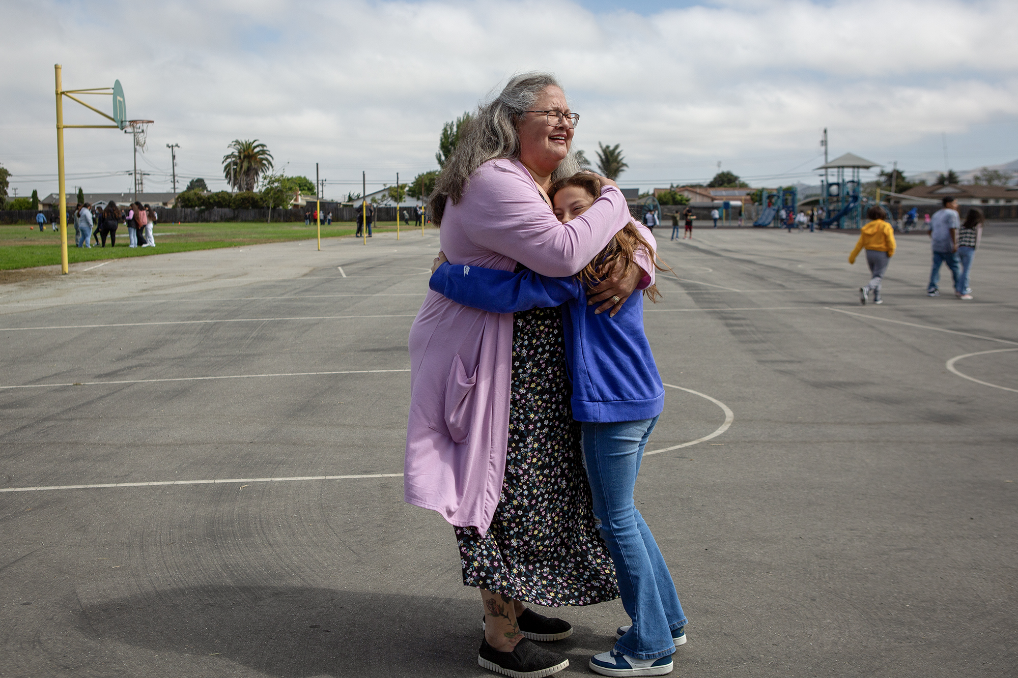 Catalina Cisneros, secretary at Loma Vista Elementary School, gets a hug from a student on the first day of school in Salinas on Aug. 8, 2023. Photo by Semantha Norris, CalMatters