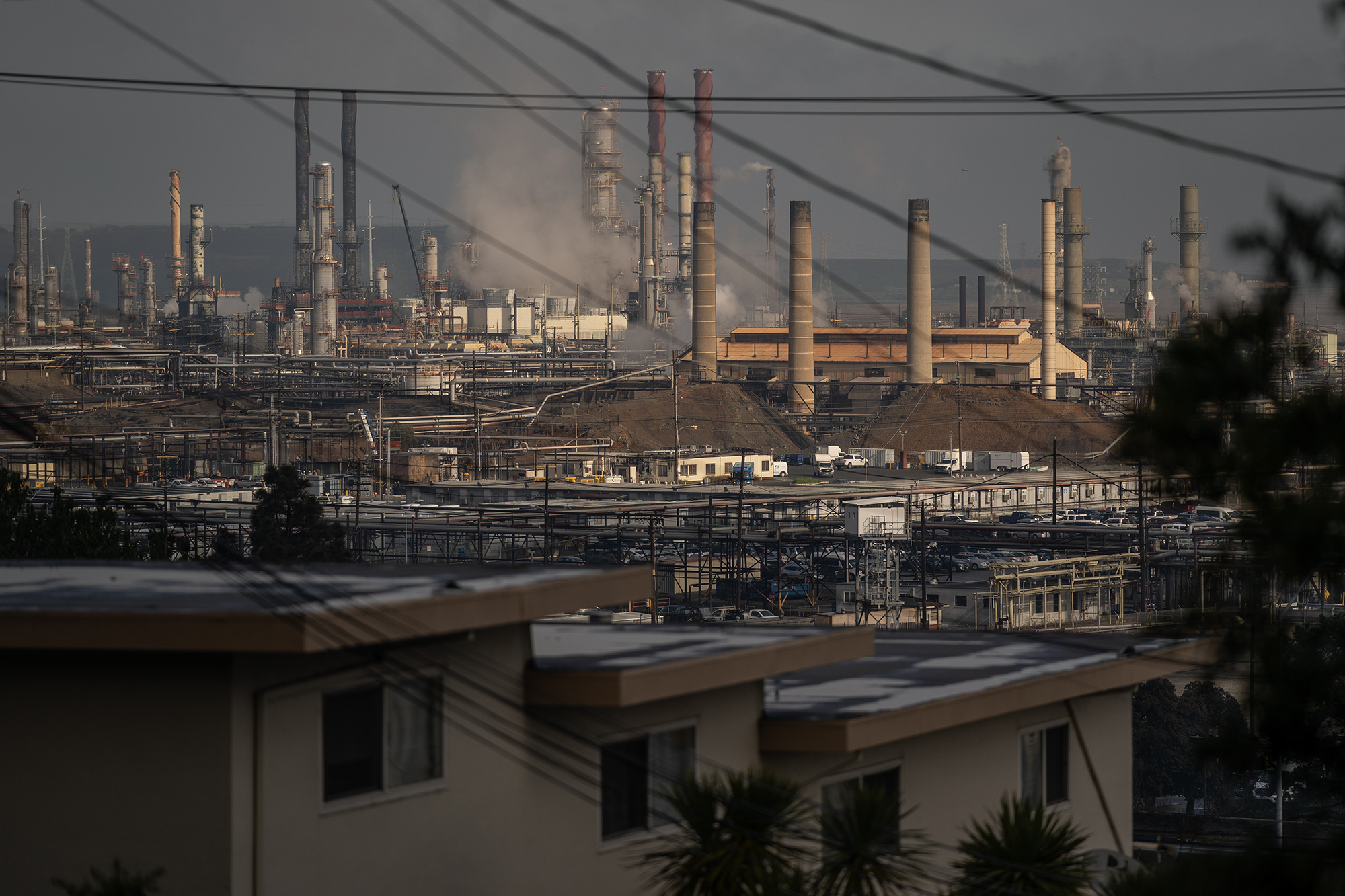 The Chevron refinery in Richmond is located behind a nearby neighborhood on Feb. 21, 2024. Photo by Loren Elliott for CalMatters