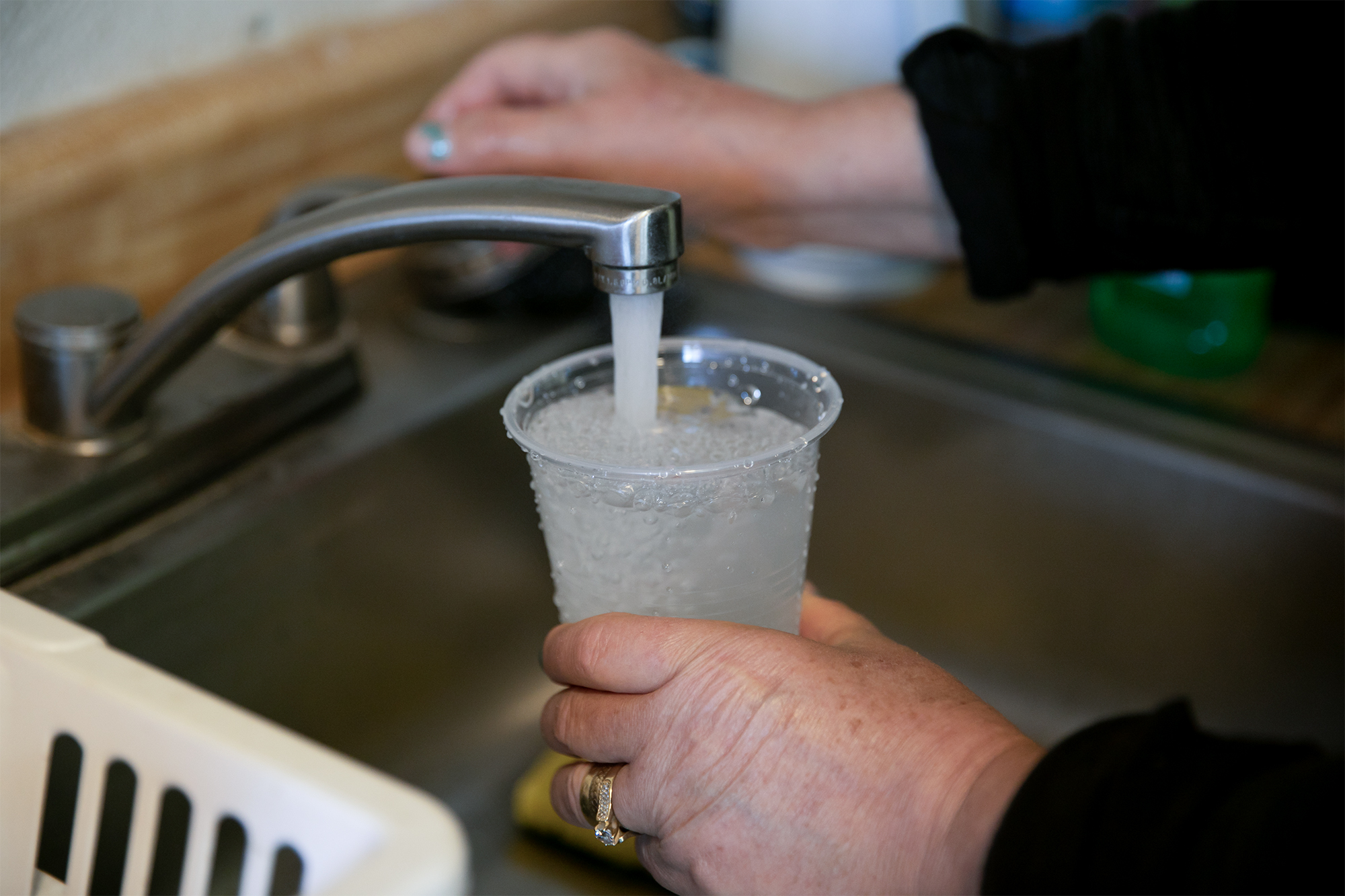 Aracel Fernandez fills a cup with tap water at her home on Nov. 10, 2020. Photo by Anne Wernikoff for CalMatters