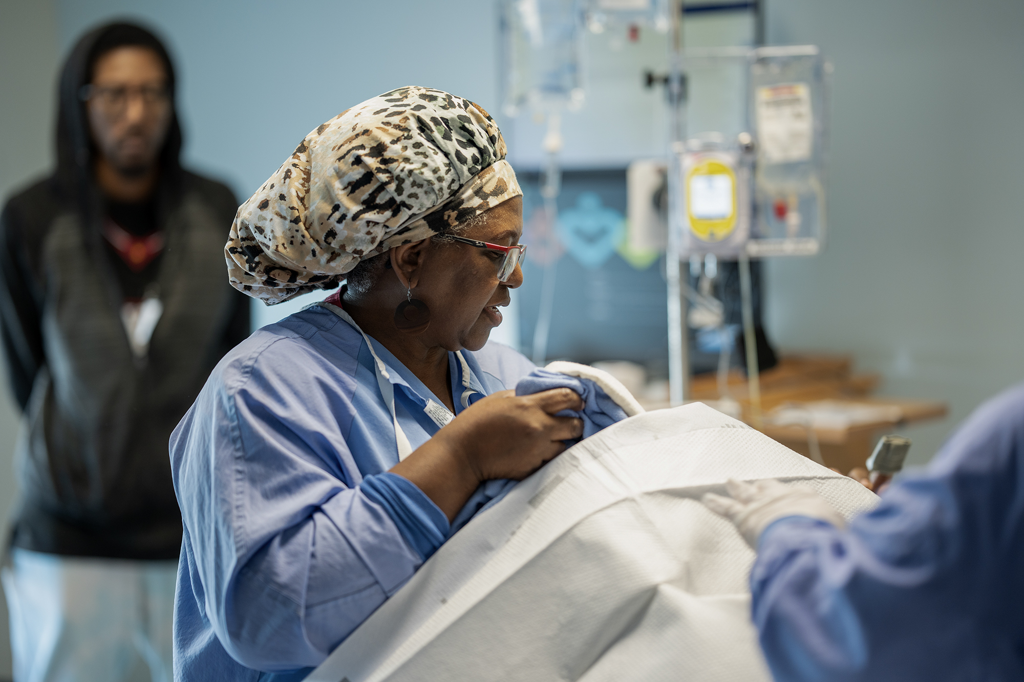 Angela Sojobi, the lead midwife at Martin Luther King Community Hospital in Los Angeles, checks on the dilation progress of Detranay Blankenship, who will soon give birth for the first time on March 22, 2024. Photo by Jules Hotz for CalMatters