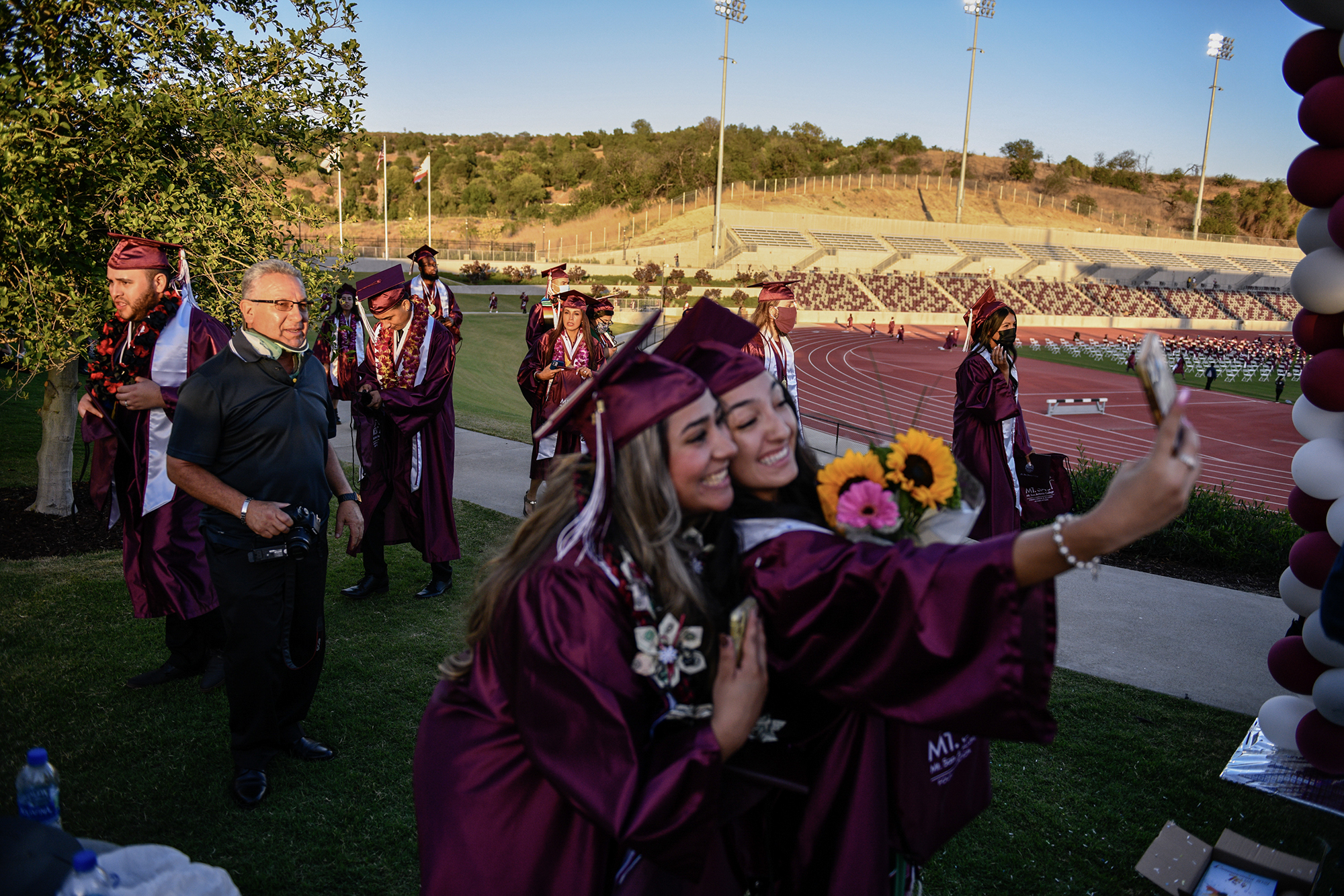 Recent graduates walk up the Hilmer Lodge Stadium ramp, while students take selfies after recieving their associates degrees at Mt. San Antonio Community College's 75th commencement ceremony, on June 11, 2021. Pablo Unzueta for CalMatters