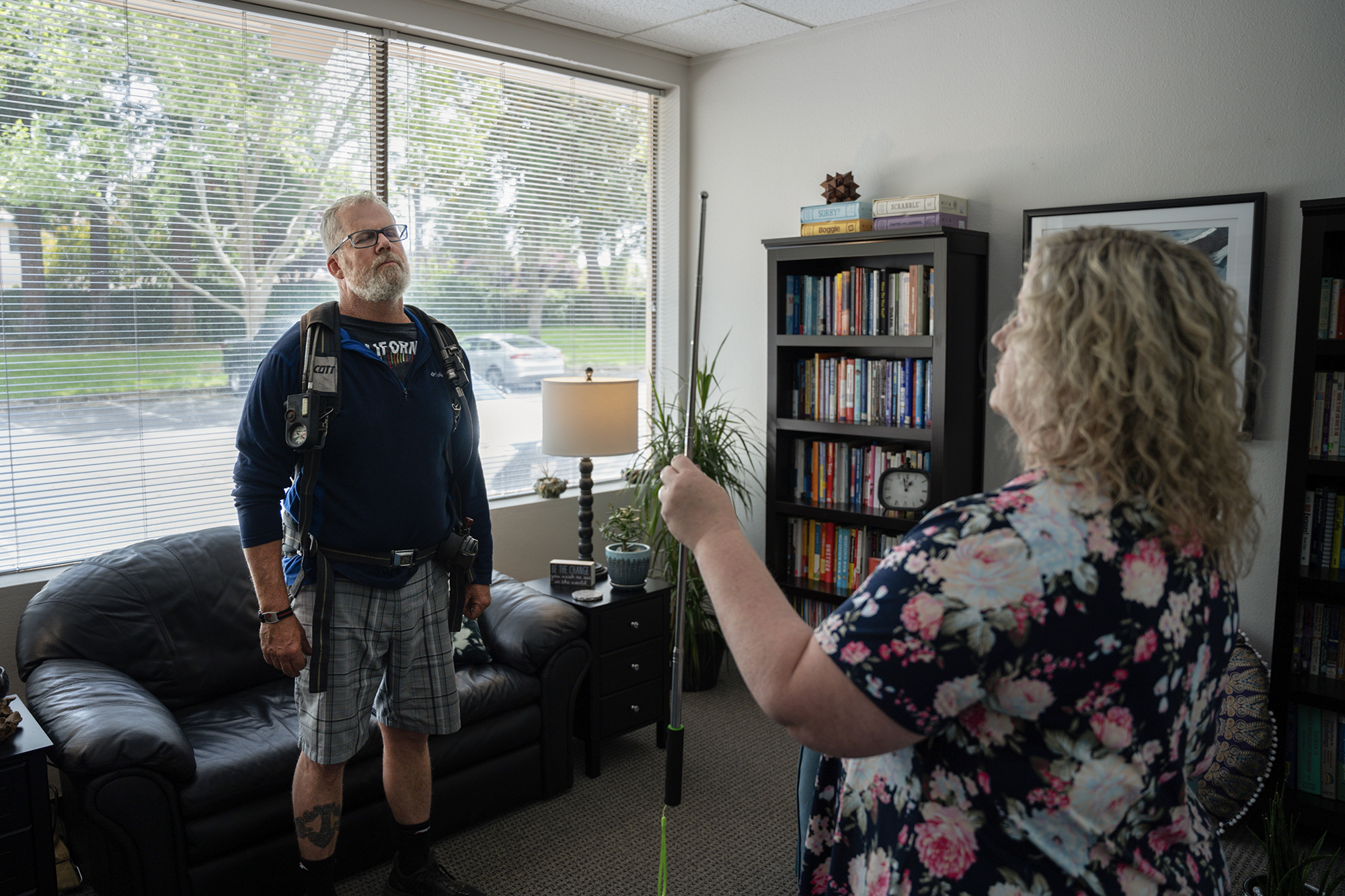 Todd Nelson and Jennifer Alexander conduct a brainspotting exercise that involves Nelsen wearing firefighting equipment at Alexander's office in Gold River on April 24, 2024. Photo by Cristian Gonzalez for CalMatters