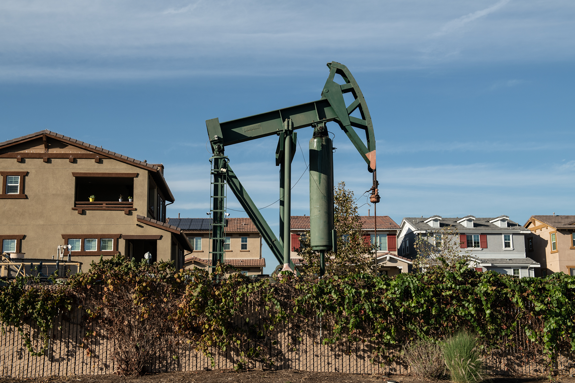 An active pump jack near homes in the city of Signal Hill in Los Angeles County on Oct. 19, 2022. Gov. Gavin Newsom signed Senate Bill 1137 in September this year, which bans new oil and gas wells within 3,200 feet of homes and schools. The bill is an effort to protect public health. Oil industries have have failed to defeat the buffer-zone bill in the Legislature, filing a petition in October to put a referendum on the 2024 ballot to overturn SB 1137. Photo by Pablo Unzueta