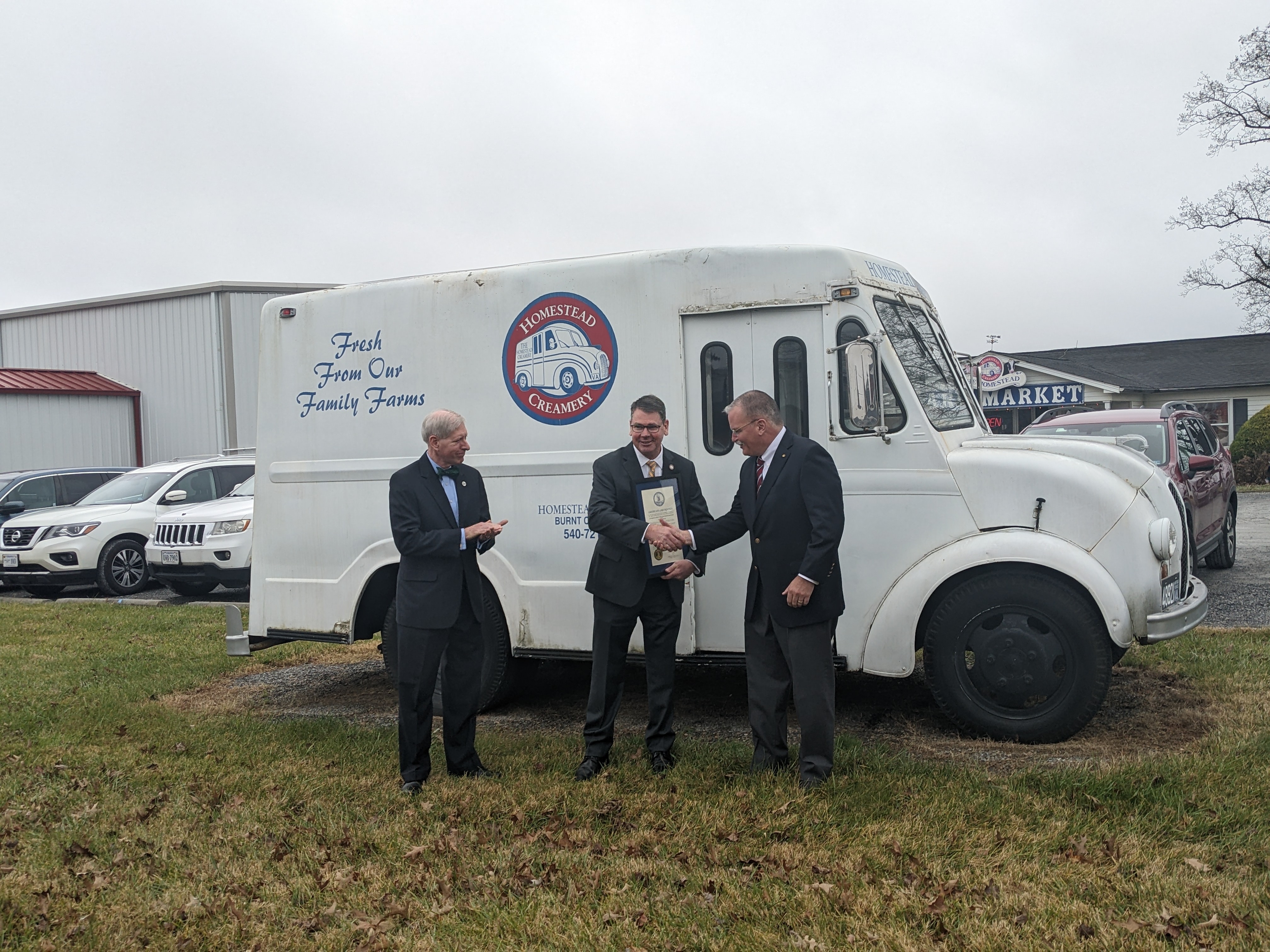 Former Del. Steve Landes, Secretary of Agriculture Matt Lohr and former state Sen. Ed Scott stood outside Homestead Creamery in Franklin County last month with a proclamation marking the 10th anniversary of the AFID program. Homestead received the inaugural AFID grant in December 2012. Photo by Megan Schnabel.