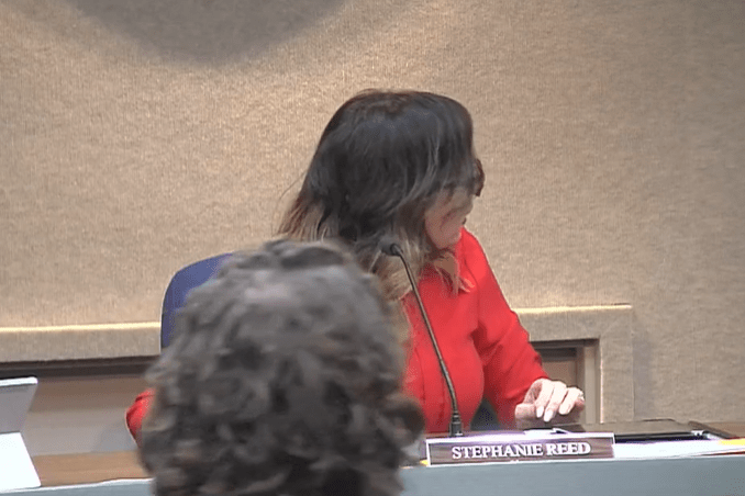 The moment -- captured on a Facebook LIve video of the meeting -- where Mayor Stephanie Reed abruptly turns to confront council member Jeff Helgeson after he was heard to mutter that she was "the stupidest person on earth." Screenshot.