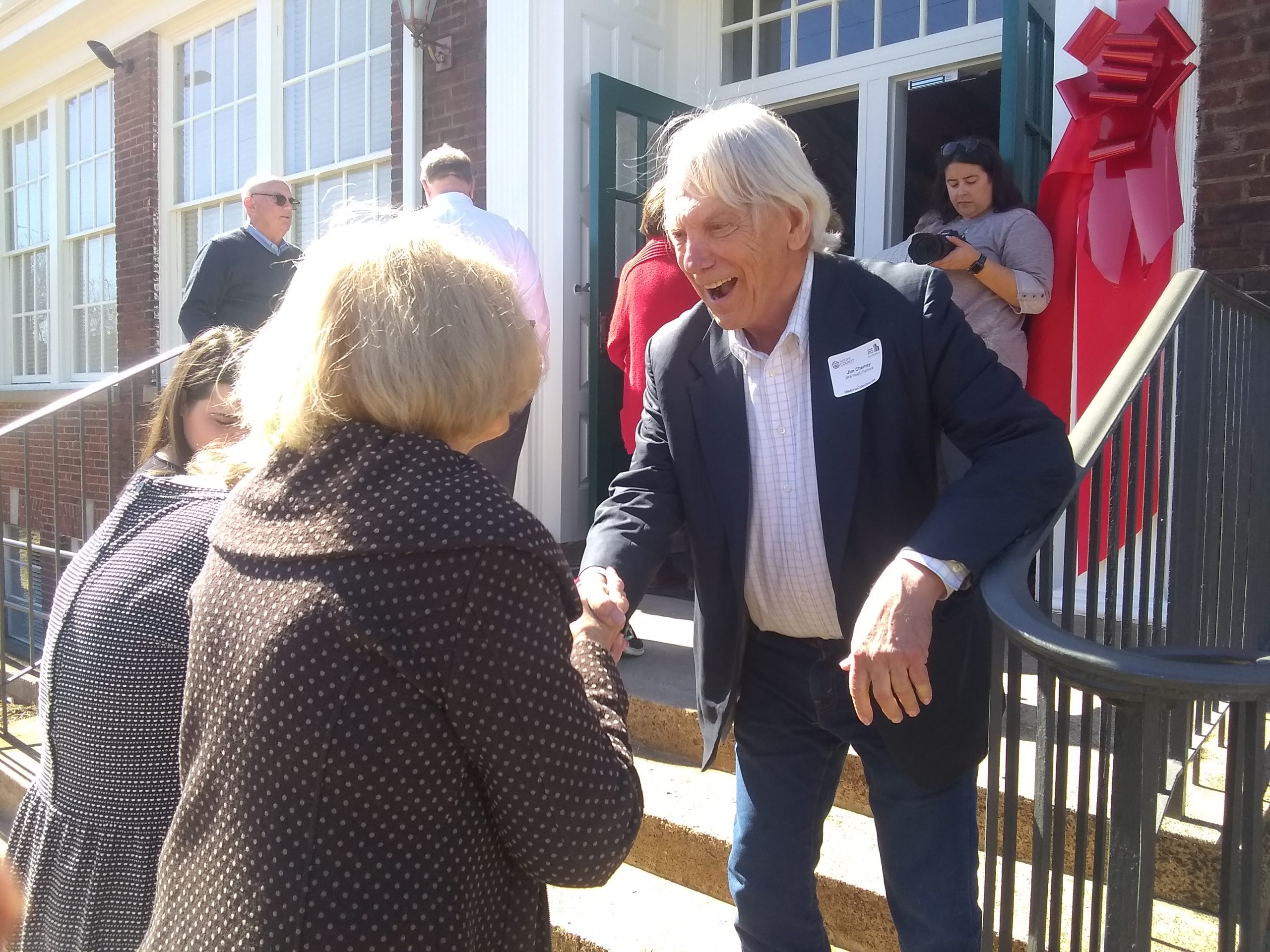 Developer Jim Cherney greets people at the ribbon-cutting. In the background, at left, is partner John Garland. Photo by Dean-Paul Stephens.