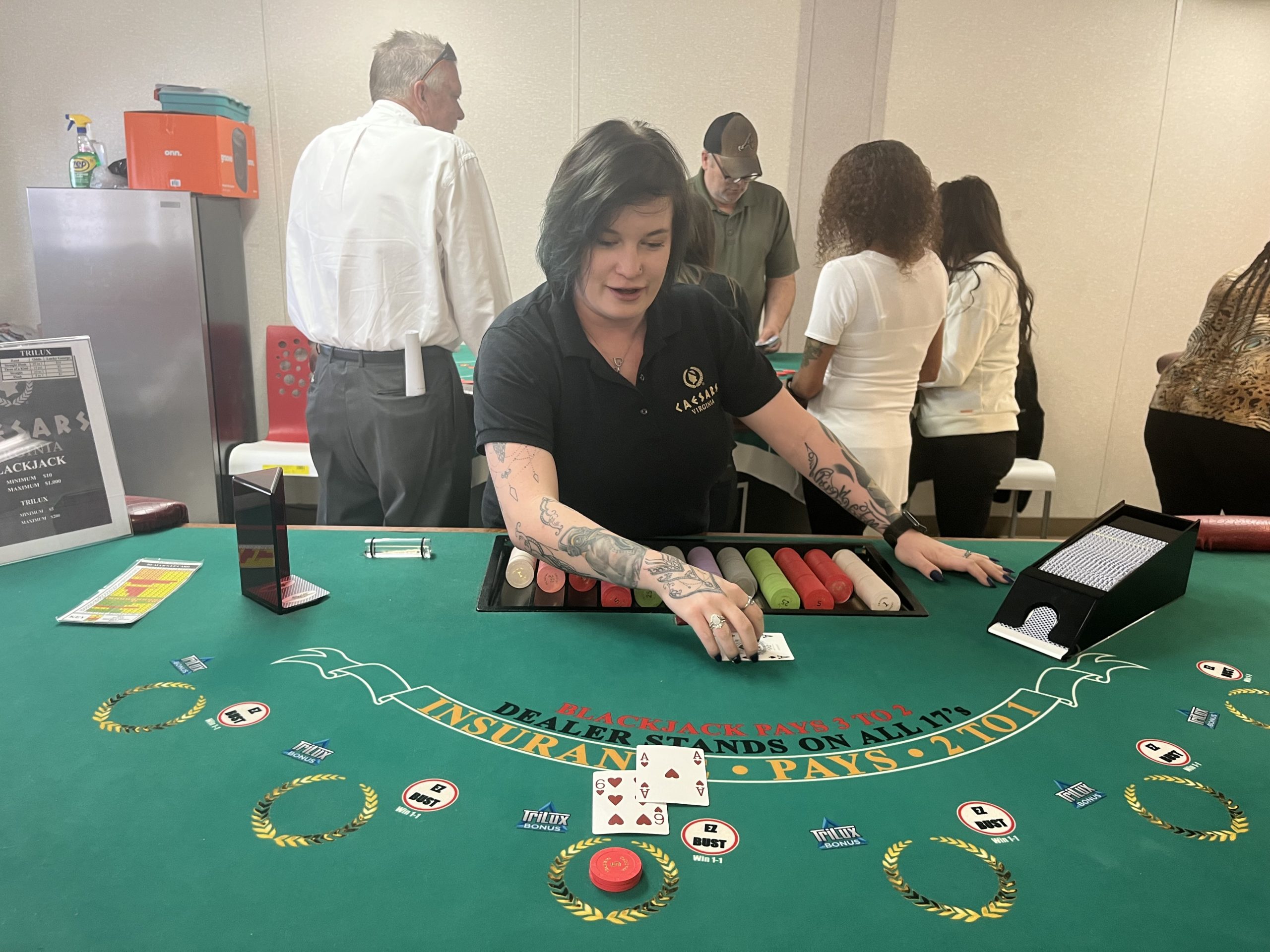 Whitney Rankin, a Caesars Virginia roulette instructor, demonstrates how to deal a blackjack hand. Photo by Grace Mamon.