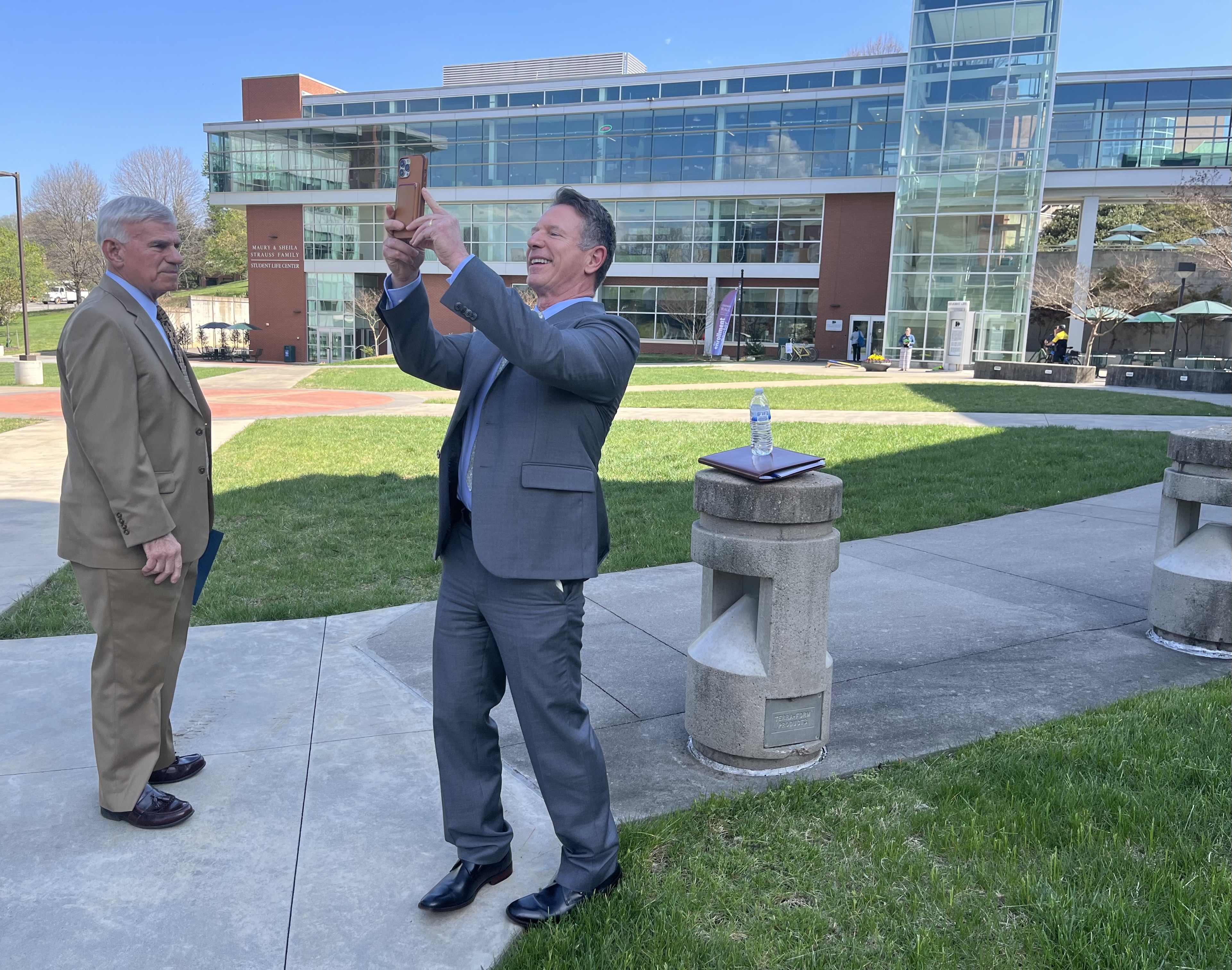 Virginia Community College Chancellor David Doré (center) stops to take a photo of the Fralin Center for Science and Health Professions as he tours campus with Virginia Western Community College President Robert Sandel on April 4. Photo by Lisa Rowan.
