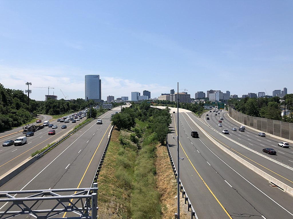 View south along Interstate 495 (Capital Beltway) from the overpass for Virginia State Route 694 (Lewinsville Road) in McLean, Fairfax County, Virginia, with the skyline of Tysons Corner visible in the distance. Courtesy of Famartin.