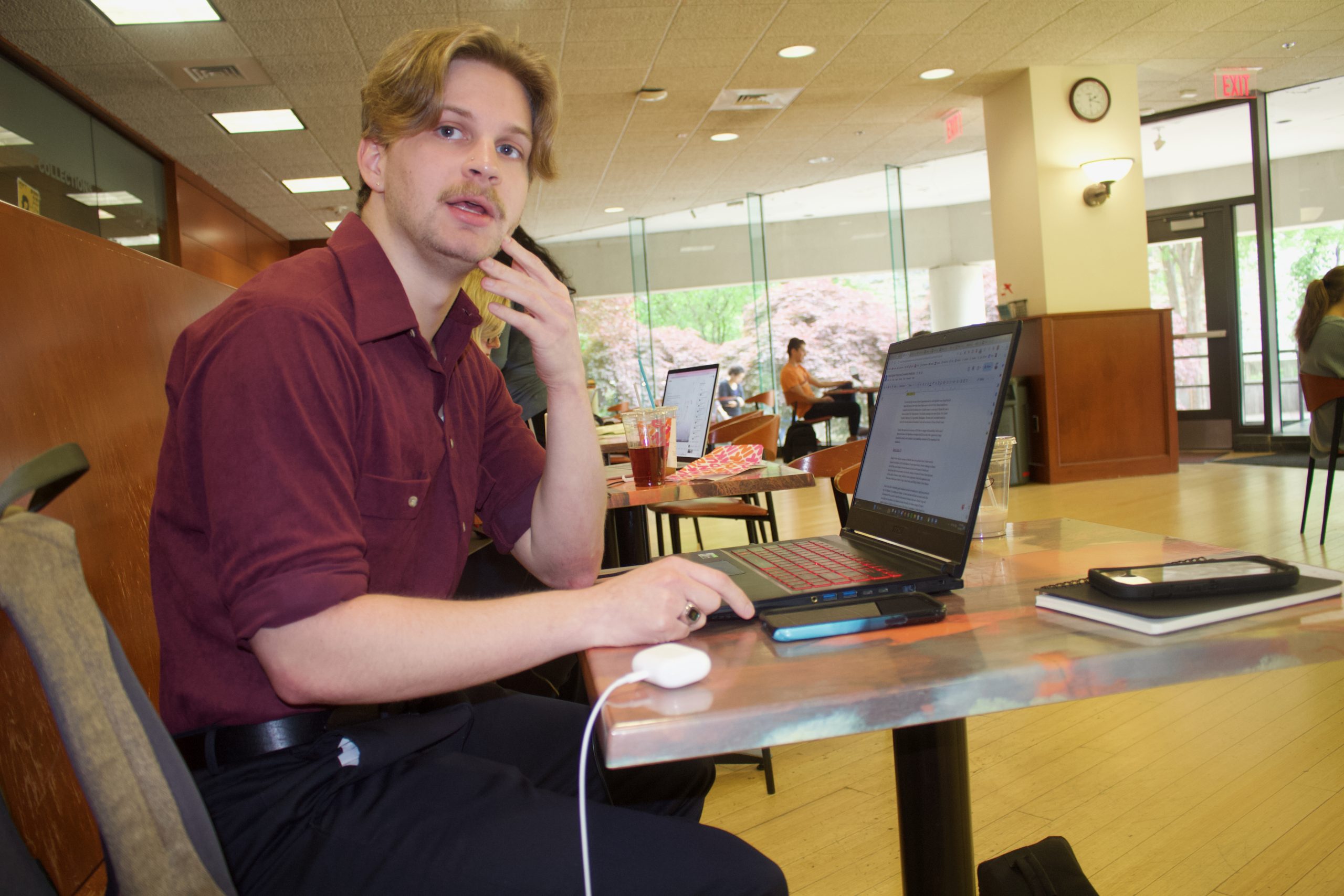 Chaz Nuttycombe works on an article for CNalysis about the primary races for Virginia's legislative elections in May in EspressOasis Cafe in Newman Library at Virginia Tech. Photo by Beth JoJack.