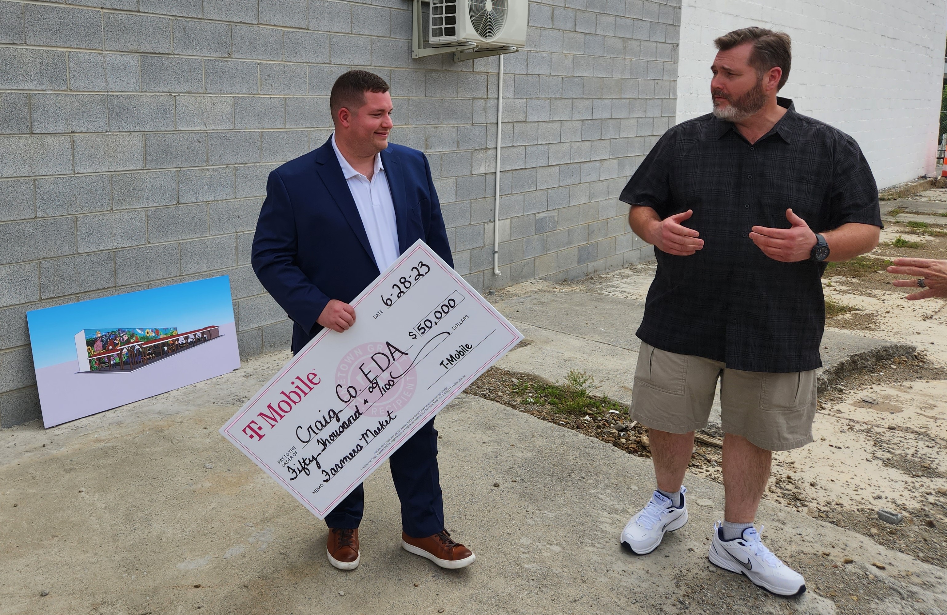Jordan Labiosa with Jesse Spence, chairman of the Craig County Board of Supervisors. Photo by Dwayne Yancey. Behind them is a rendering of the covering for the farmers market. Photo by Dwayne Yancey.