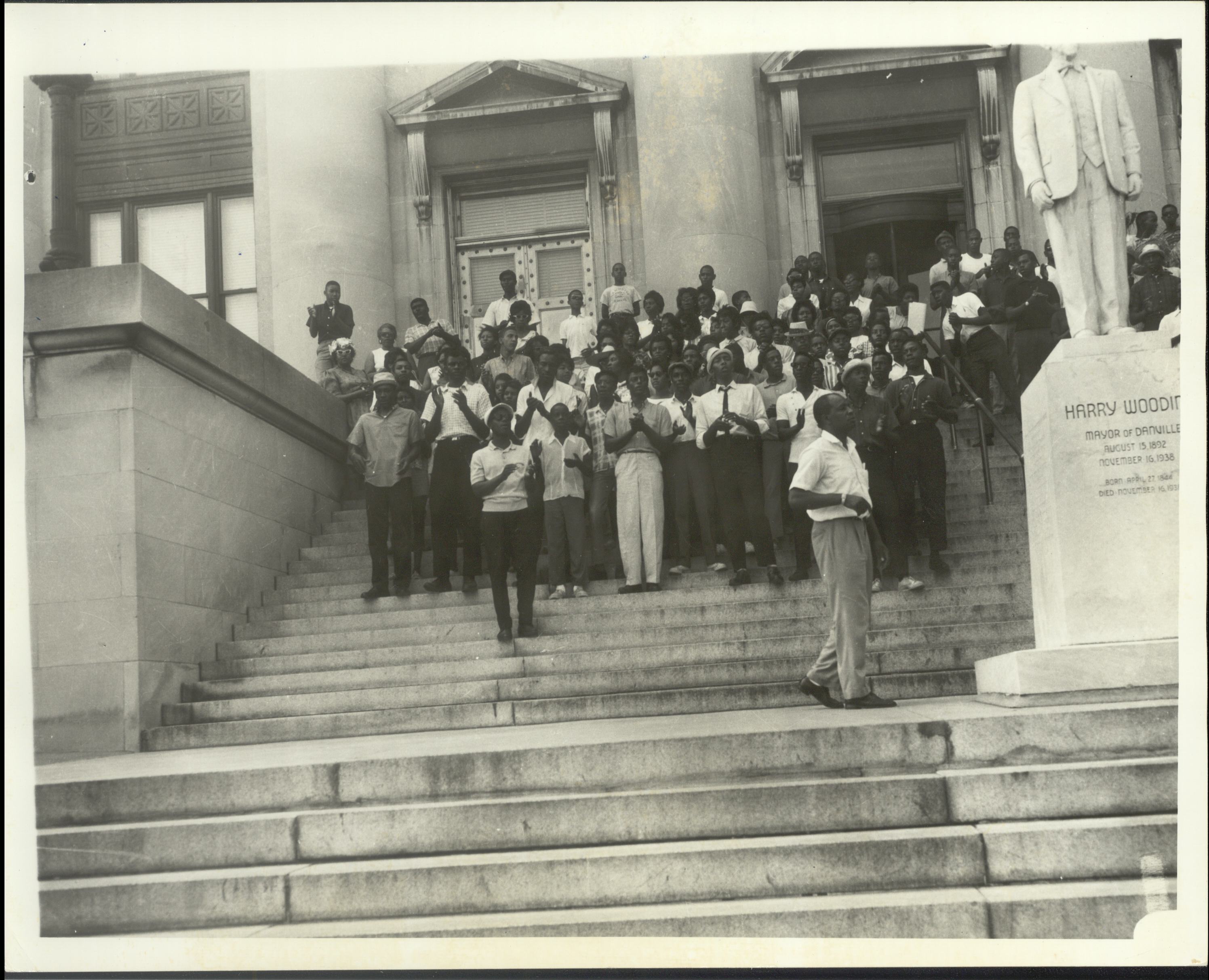 A crowd of demonstrators stands on the steps outside the Danville municipal building
