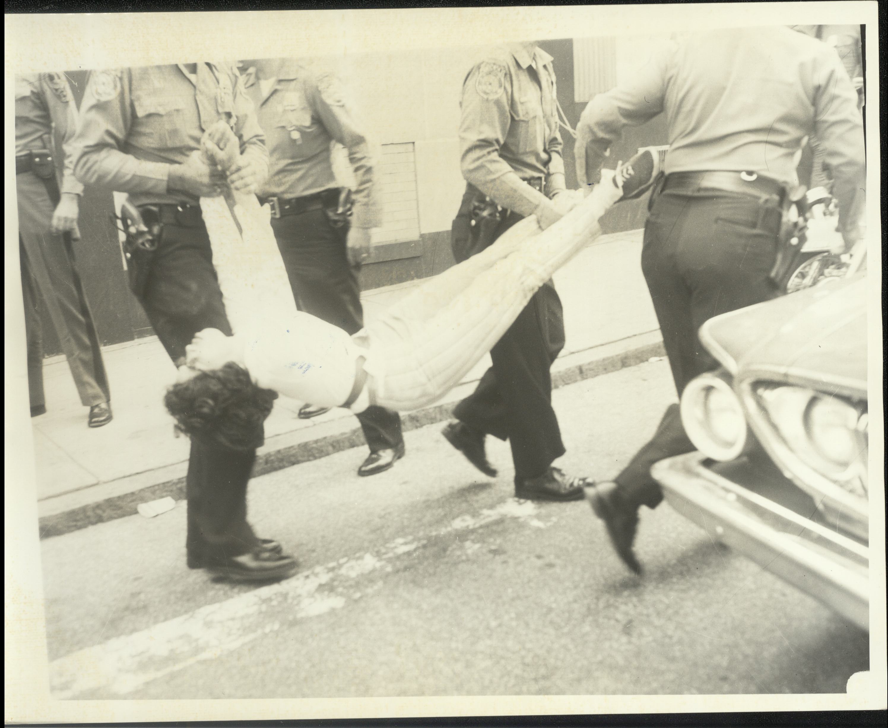Danville police carry away a protester by their arms and legs