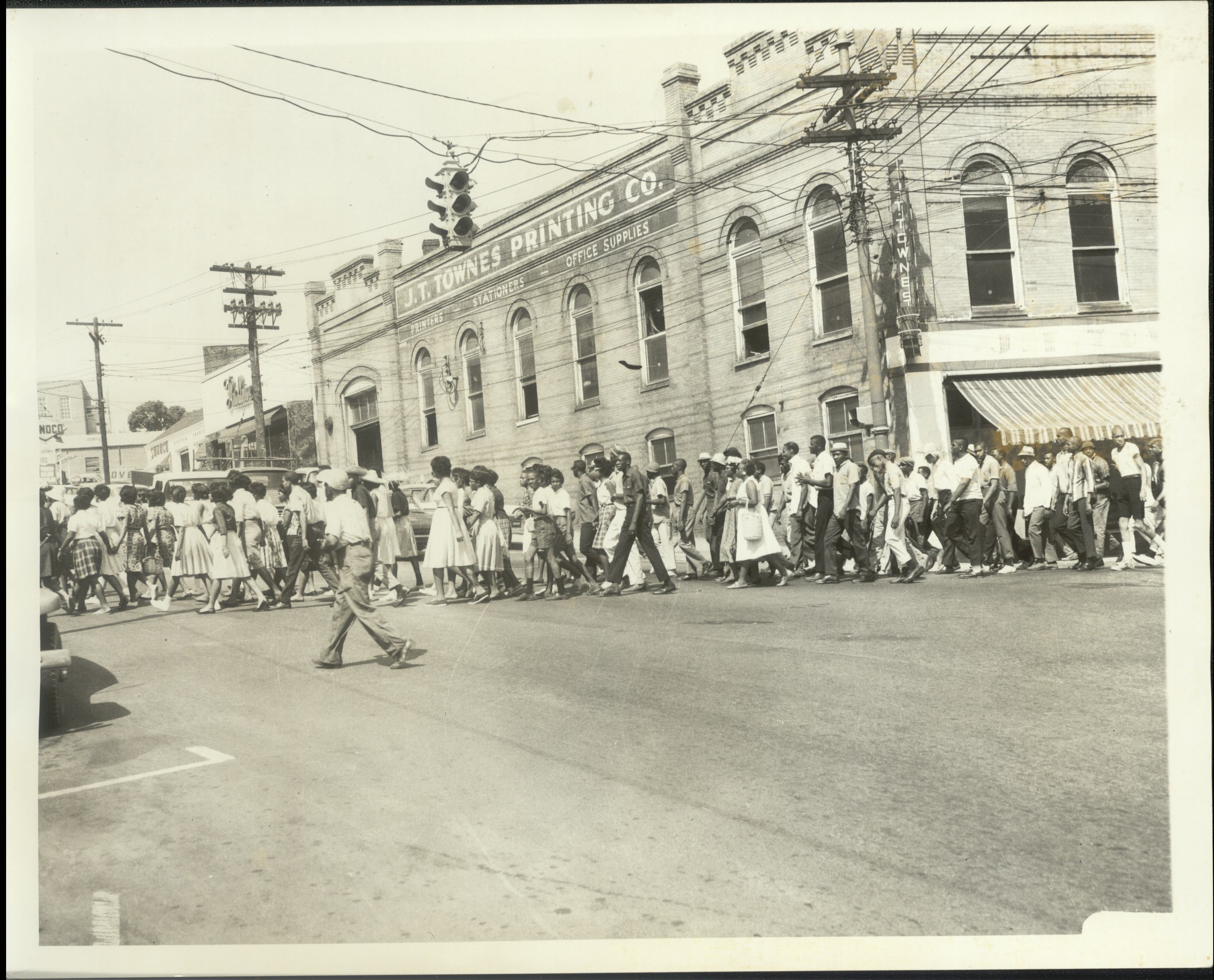 A large group of demonstrators crosses a Danville street on foot