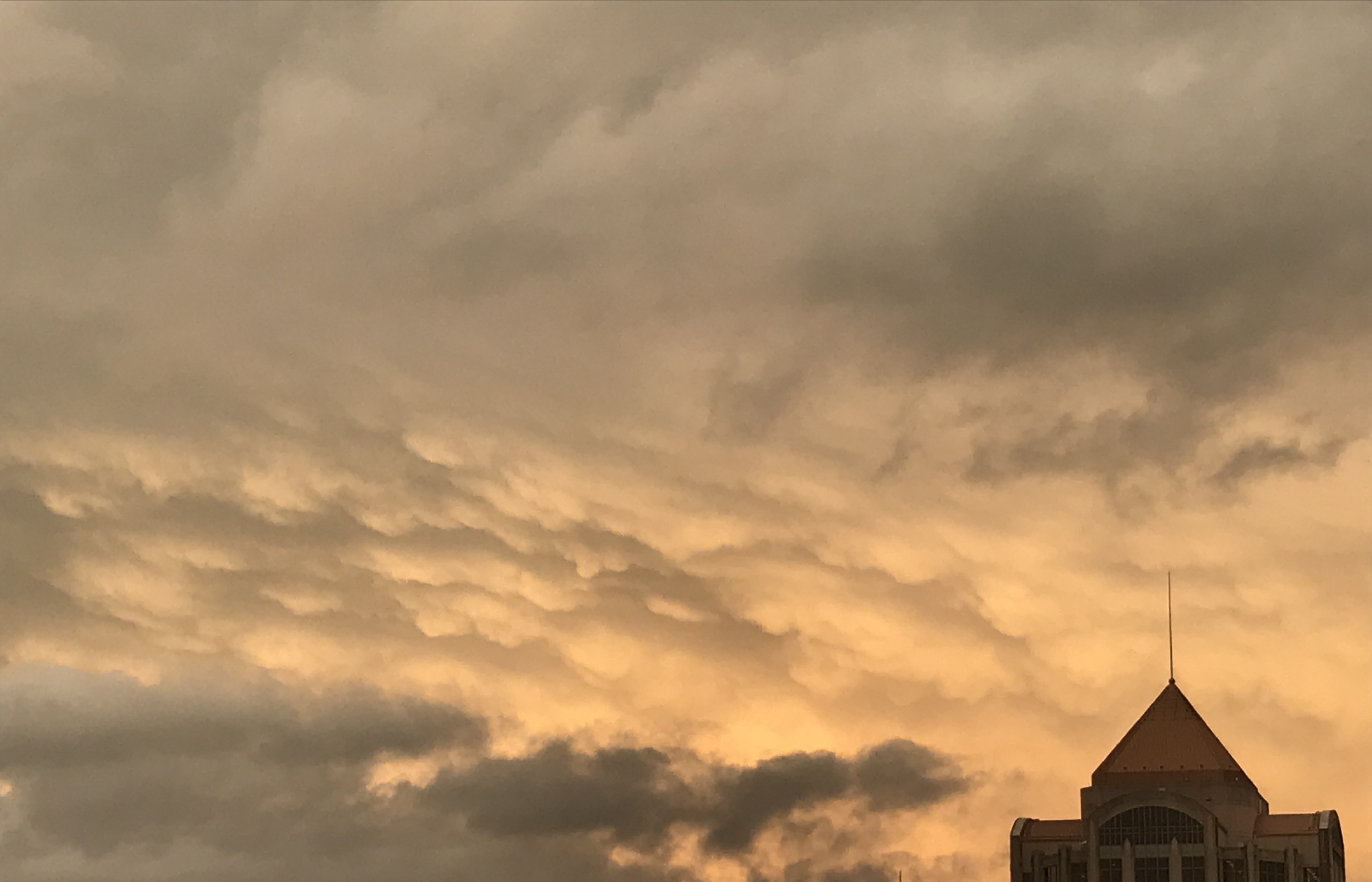 Late-day sunshine created an unusual mural of colors on the eastern sky, behind the Wells Fargo Tower in downtown Roanoke, as the rain shield from the remnants of Hurricane MIchael pulled eastward on Oct. 10, 2018. Photo by Kevin Myatt.