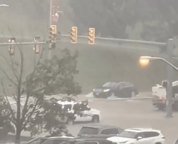 Vehicles ply flood waters at Beamer Way and Southgate Drive outside Lane Stadium. Courtesy of Ben Huber.