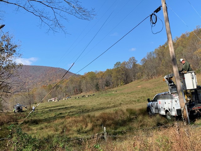 A man in a bucket truck works on a utility pole.