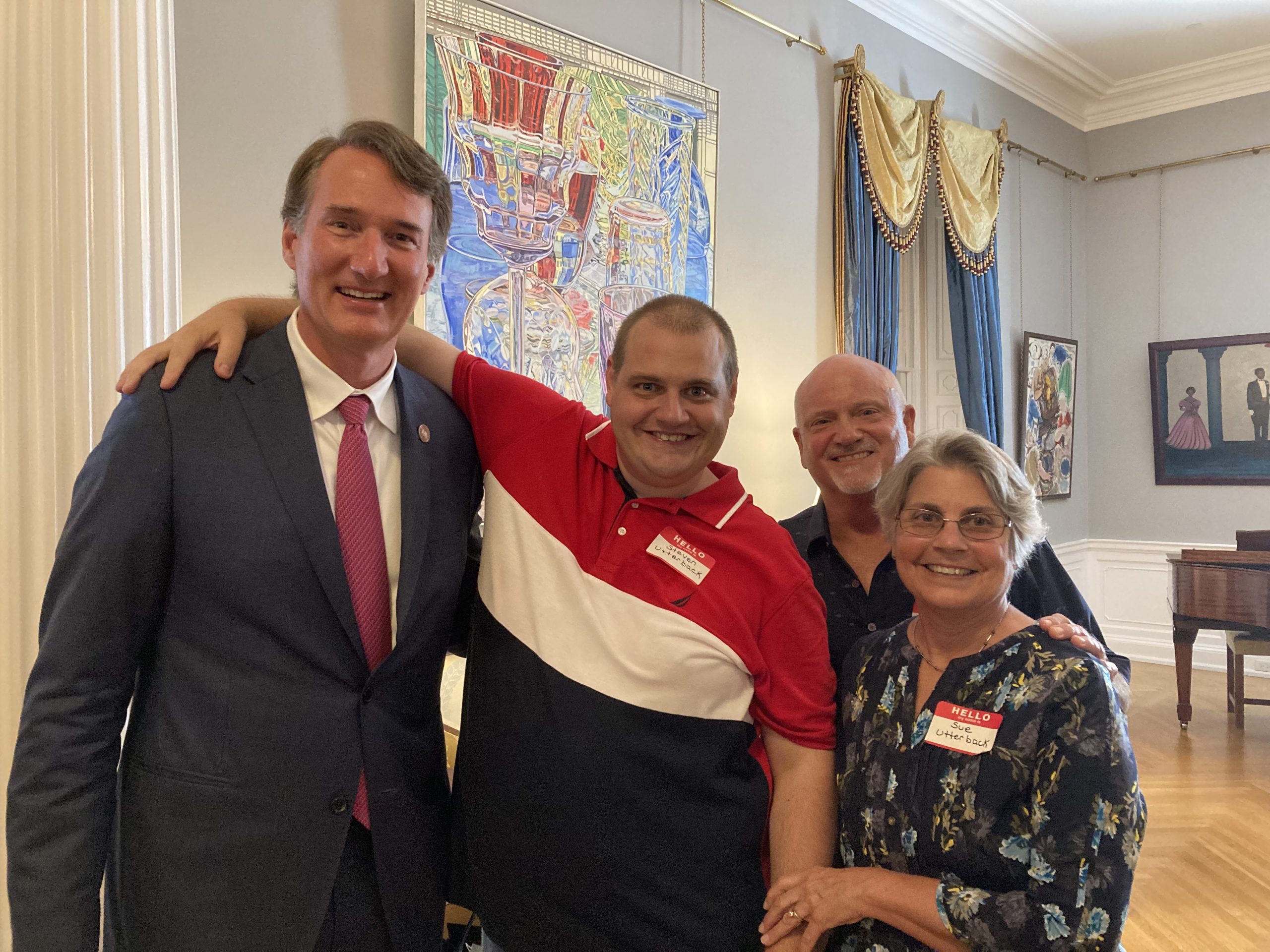Sue Utterback, right, pose with Gov. Glenn Youngkin with her husband and her disabled son, Steven, center. They traveled to Richmond to discuss the governor's proposal to expand the developmental disability waiver.