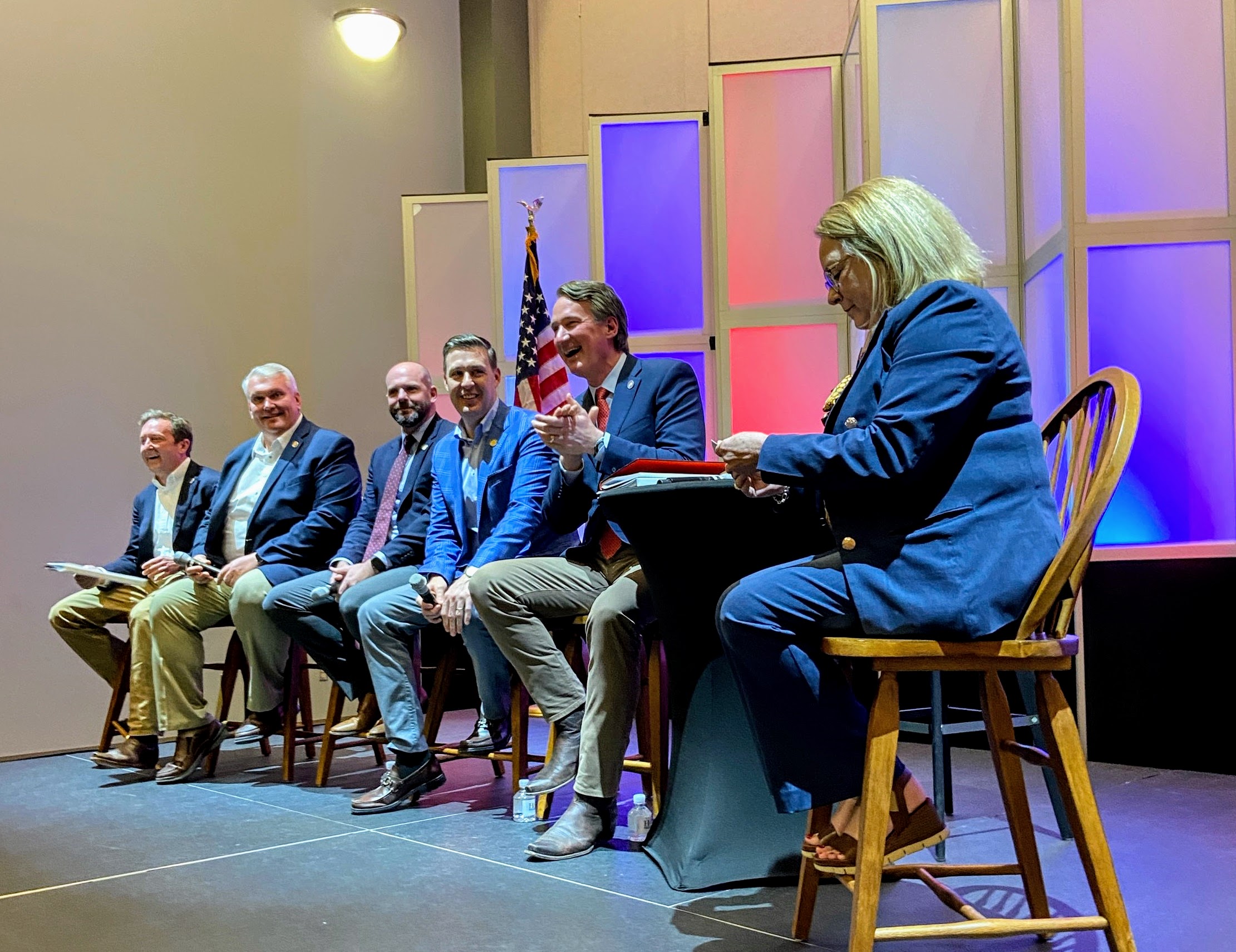 Gov. Glenn Youngkin seated on a panel among five other people.
