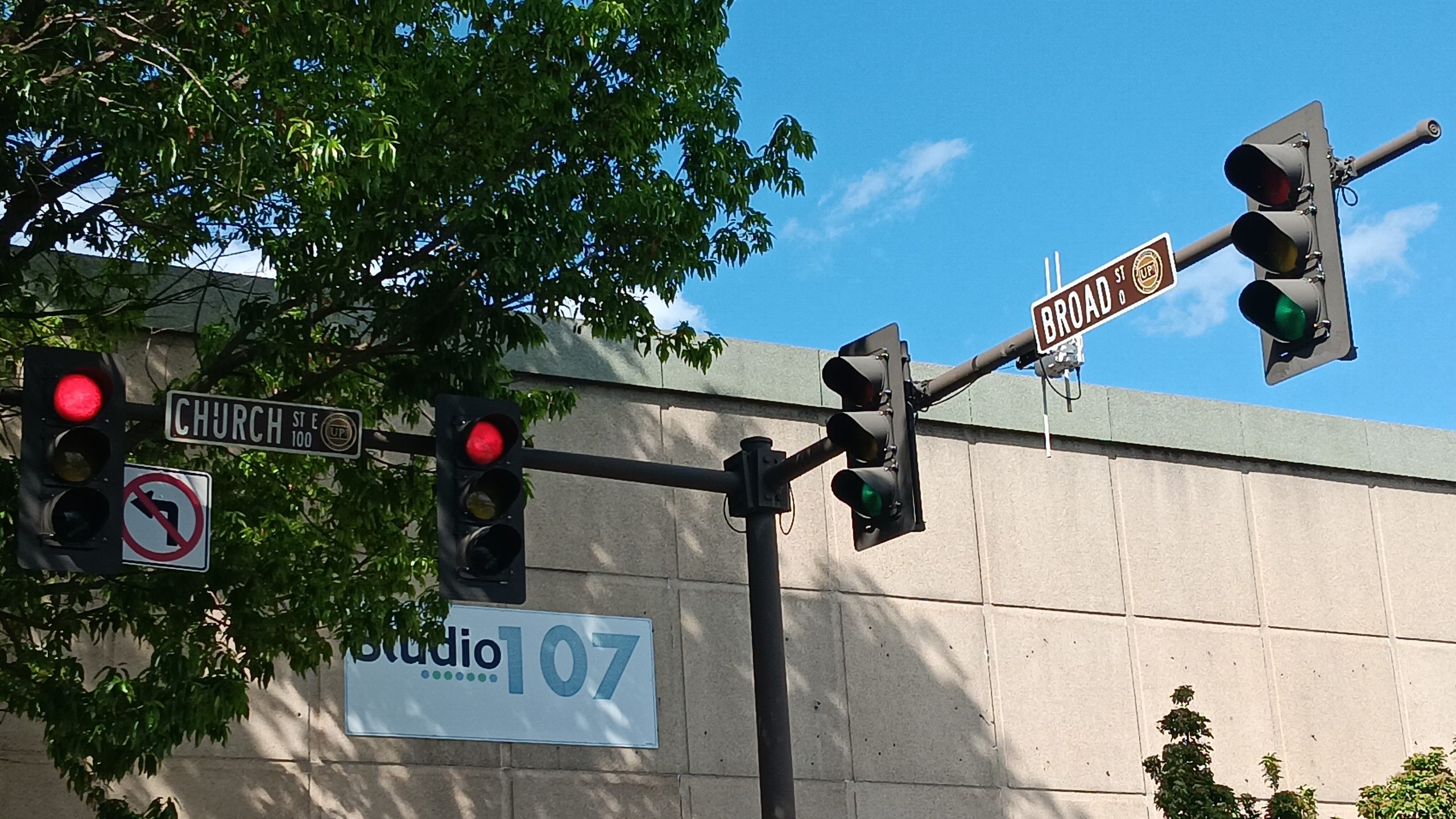 red stoplights in front of a blue sky