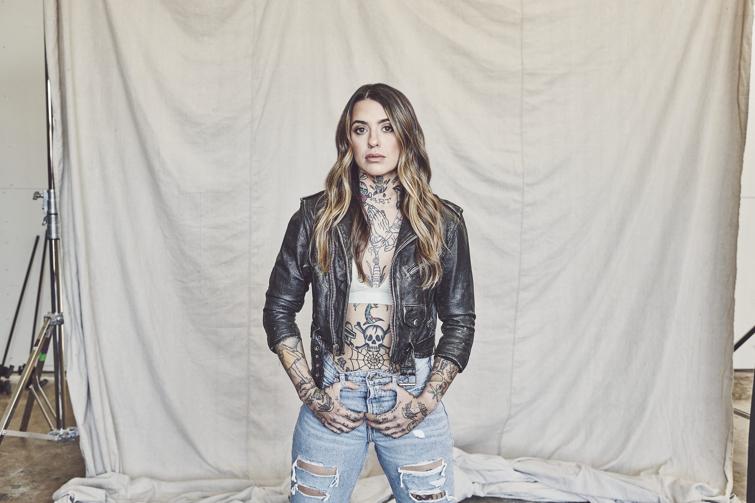 Morgan Wade posing in front of a white sheet background.