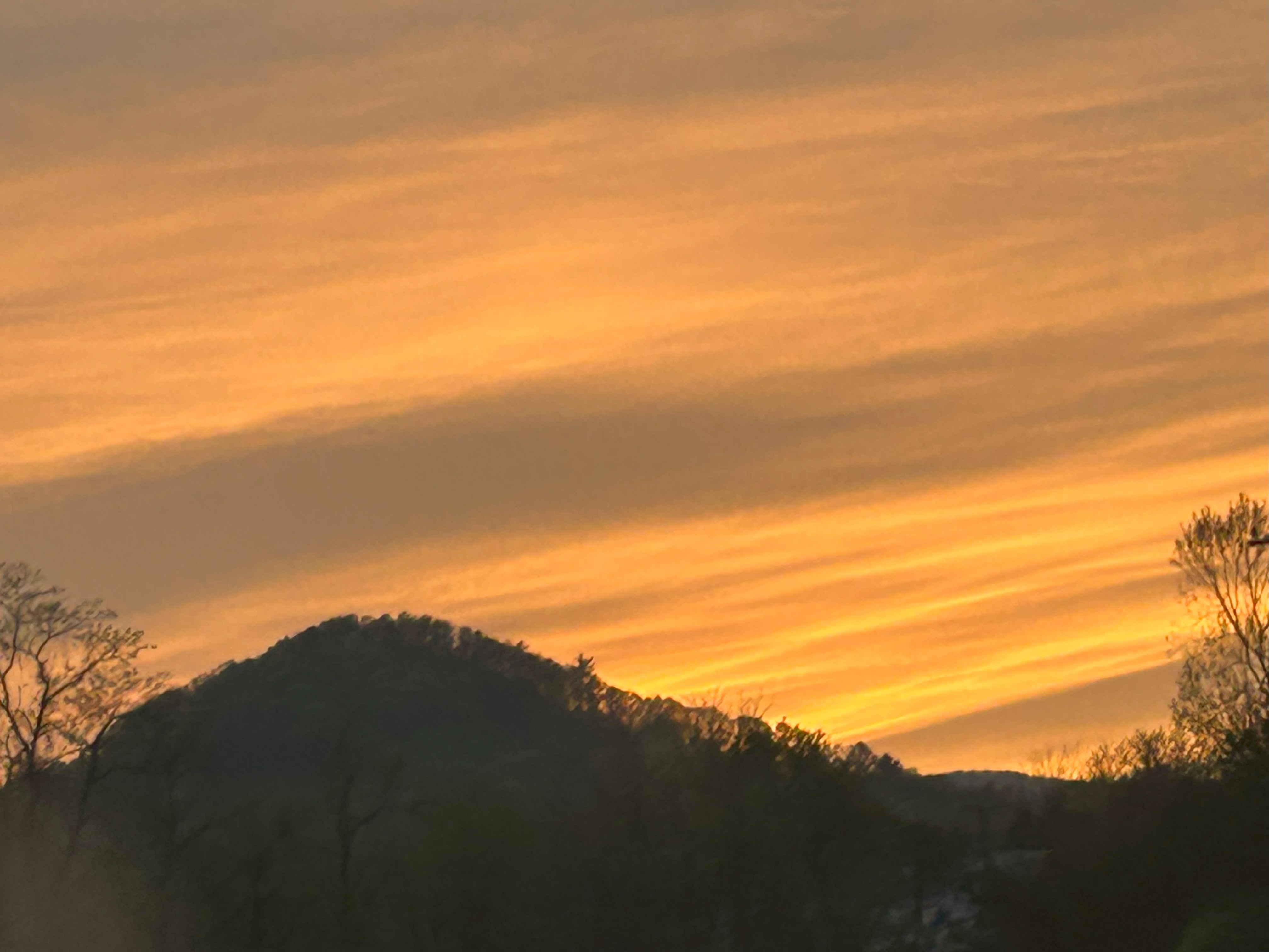 A cirrus-enhanced sunset over Sugarloaf Mountain in southwest Roanoke County looks blazing on a recent April evening. Warmer temperatures are ahead next week after some cool mornings this week. Photo by Kevin Myatt.