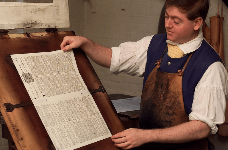 A re-enactor at Colonial Williamsburg show how a newspaper in colonial Virginia was assembled. Courtesy of Colonial Williamsburg Foundation.