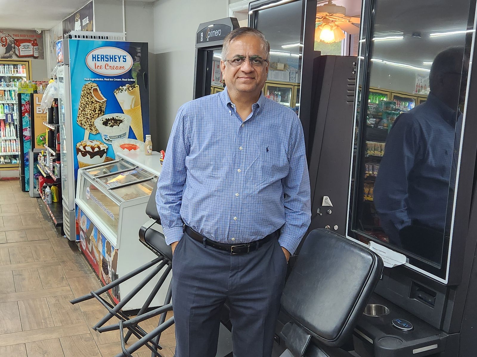 Dharmendra Patel standing in front of shut-down skill games inside a convenience store.