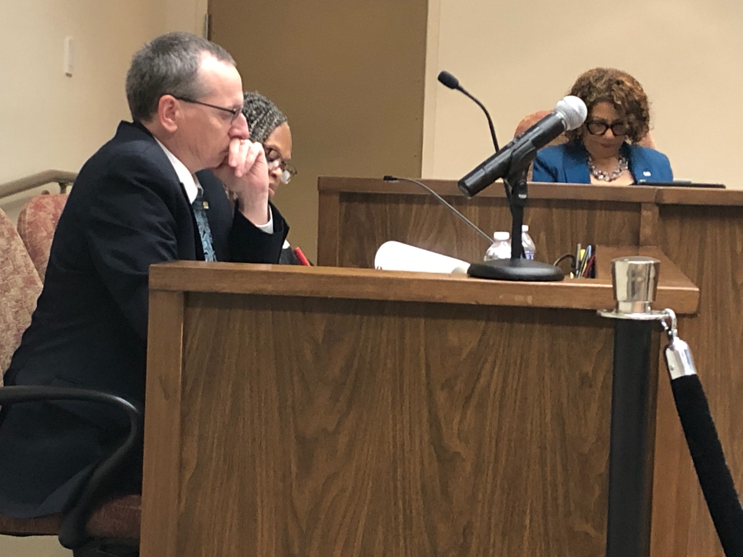 Bob Cowell sitting at a table in the Roanoke City Council chambers.