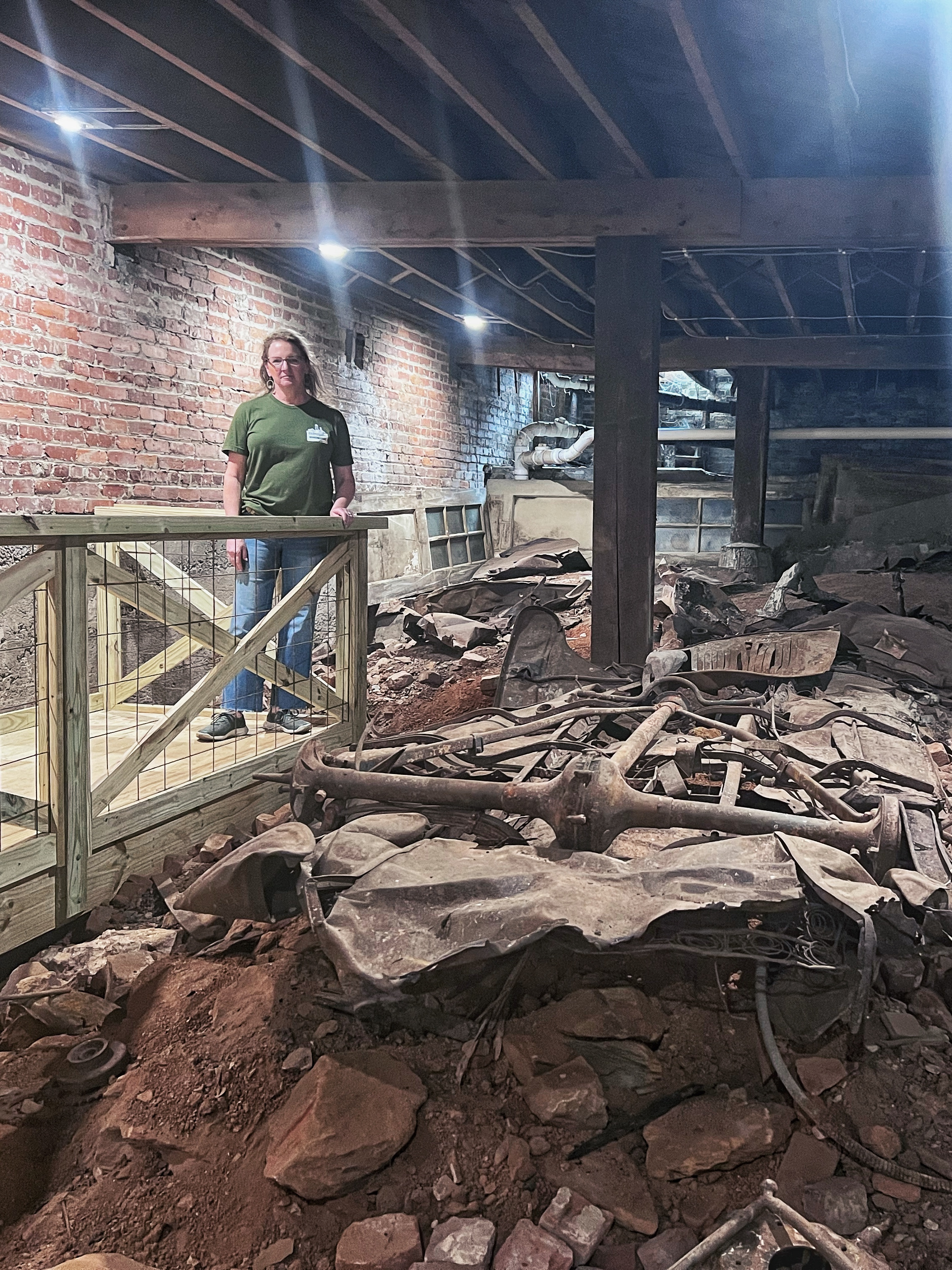 Beth Graham, co-owner of the Moonshine Explosion museum in Rocky Mount, stands near the remains of one of three Model T's that crashed through the first floor and into the basement after a moonshine-fueled fire in 1930. 