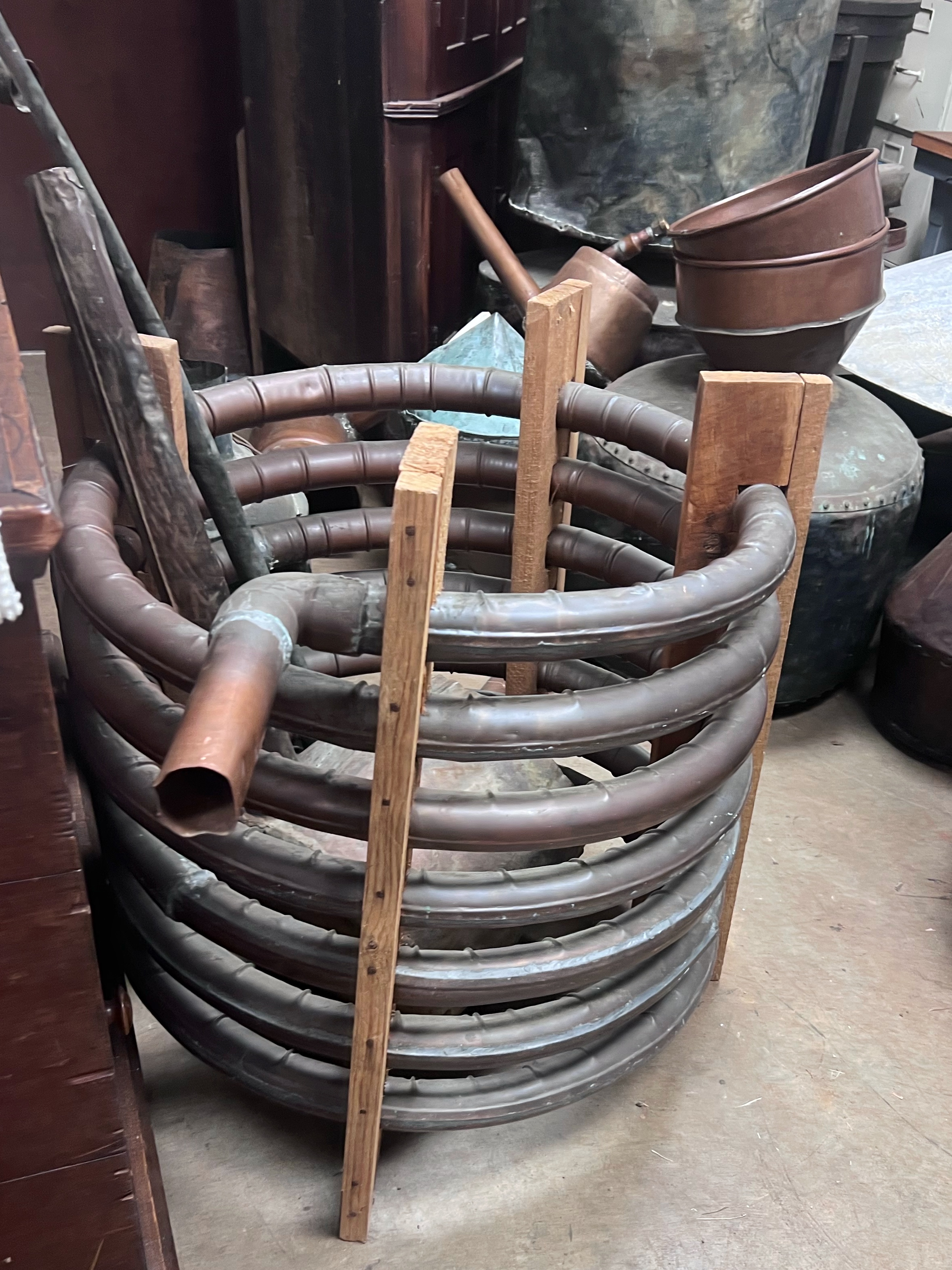 A copper worm, a coiled copper tube that would have been used in a still to condense steam back into liquid moonshine. It's about knee high.